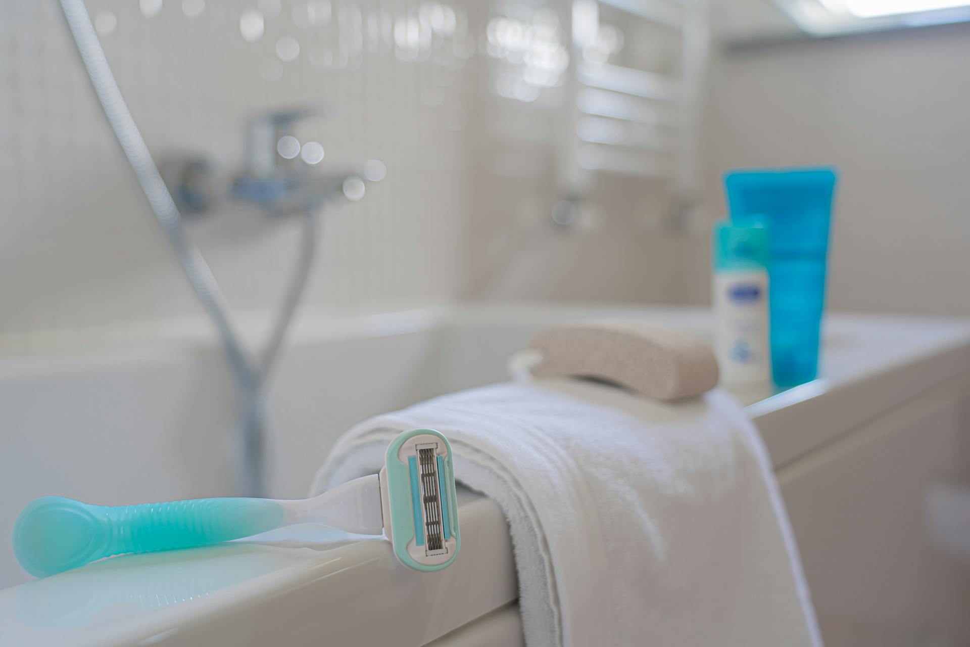 Una maquinilla de afeitar y una toalla en un cuarto de baño | Fuente: Pexels