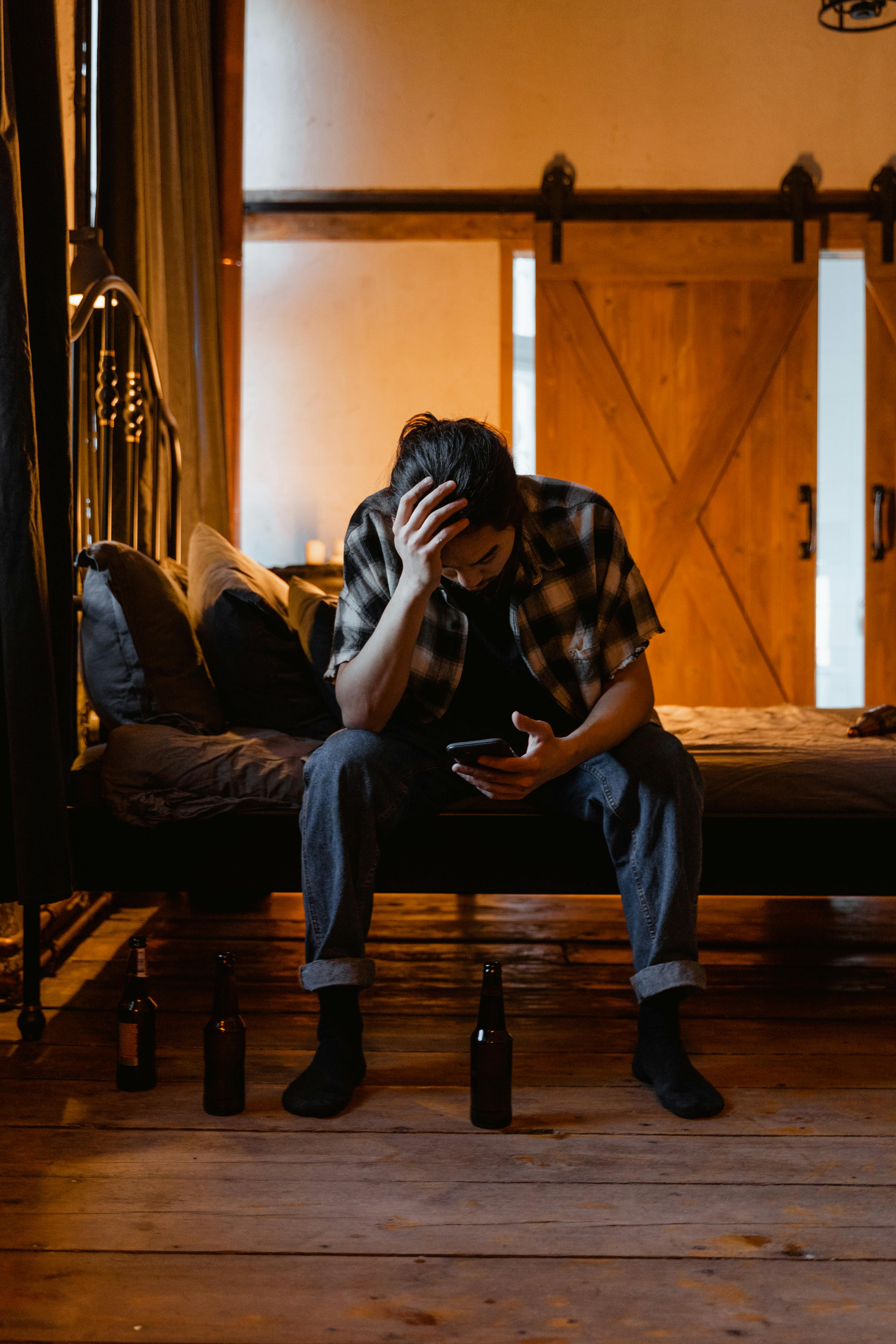 Un hombre cansado sentado en una cama | Fuente: Pexels