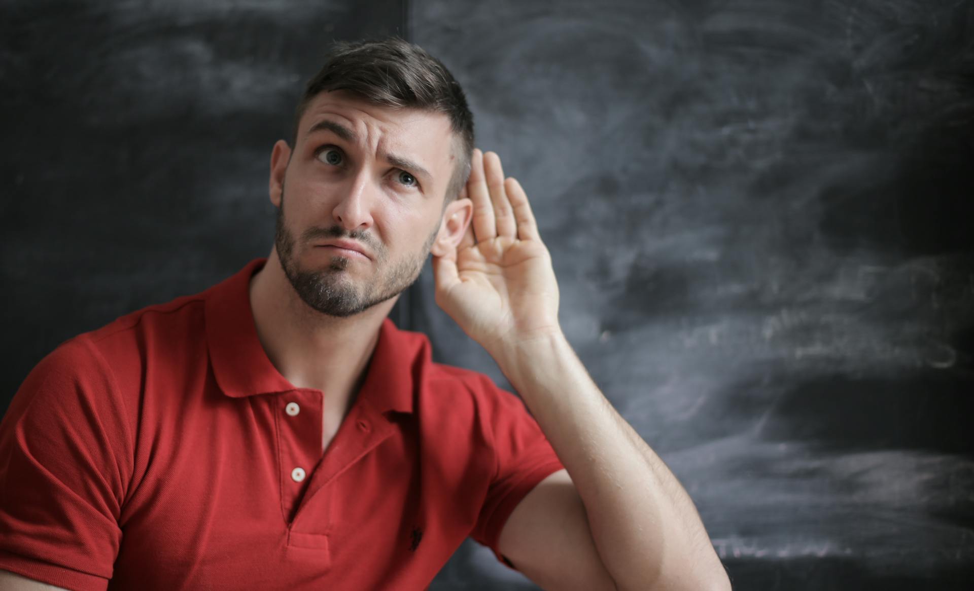 Un hombre con la mano colocada detrás de la oreja | Fuente: Pexels