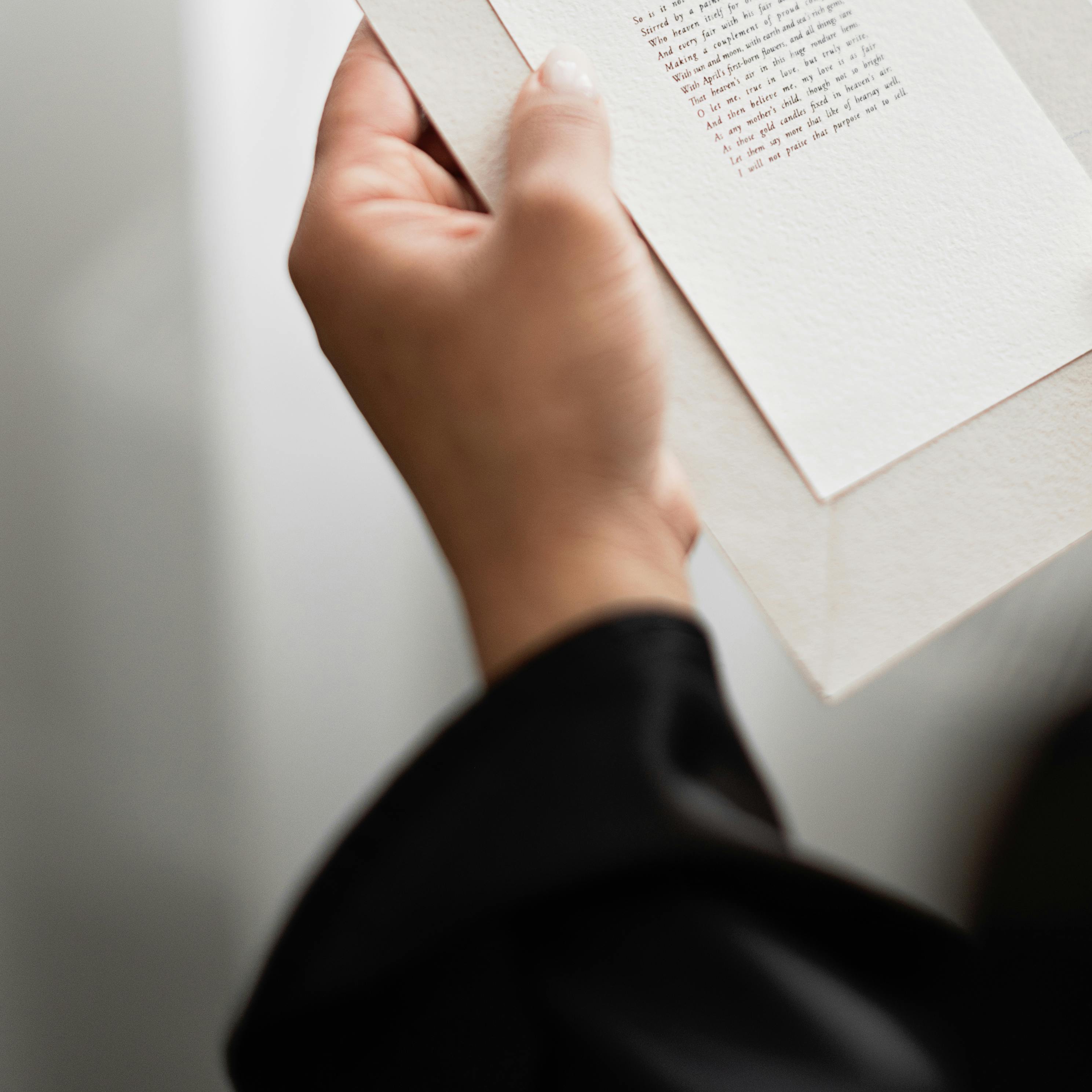 Una mano sujetando una invitación impresa | Fuente: Pexels