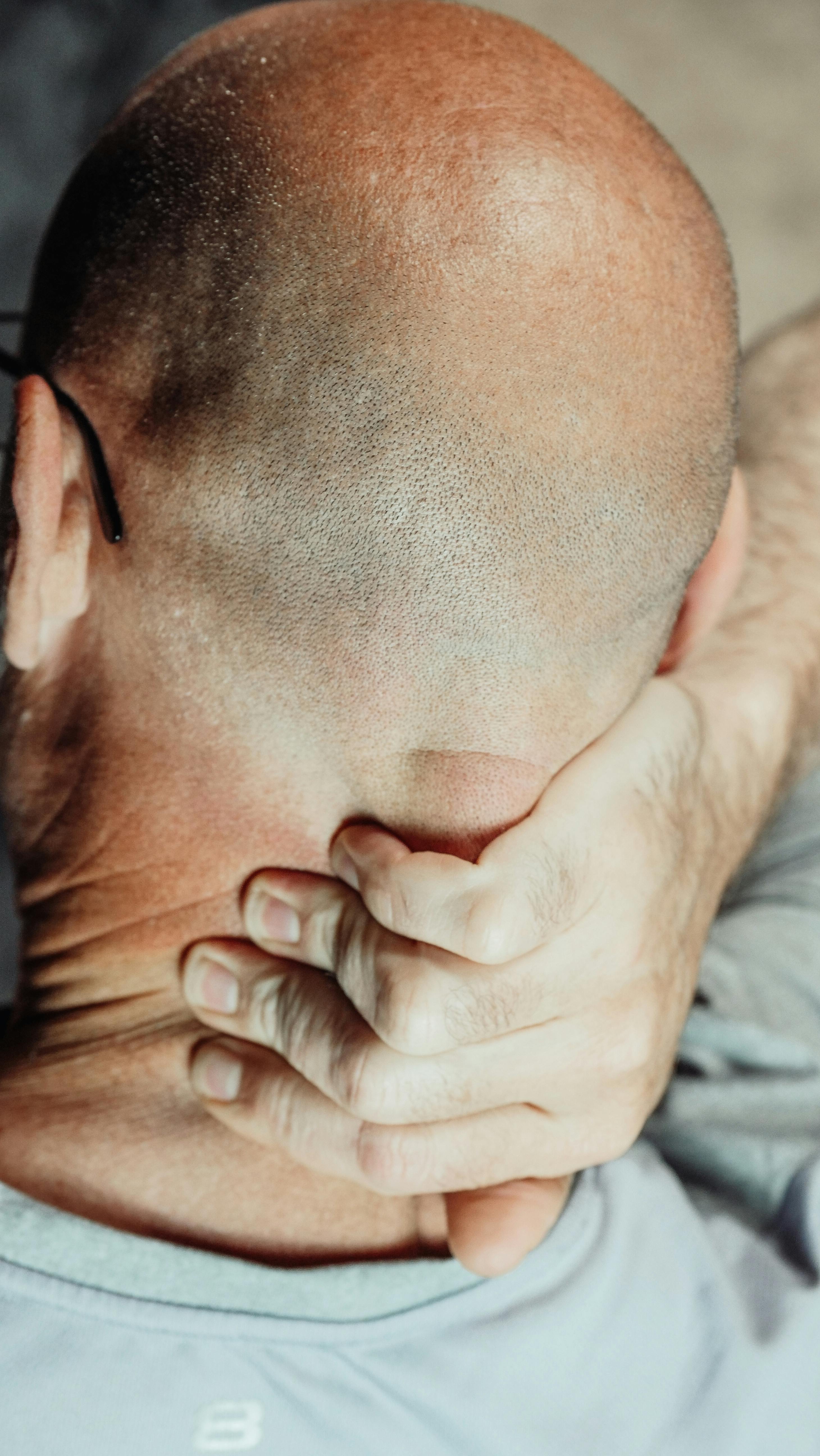 Un hombre tocándose la nuca | Fuente: Pexels