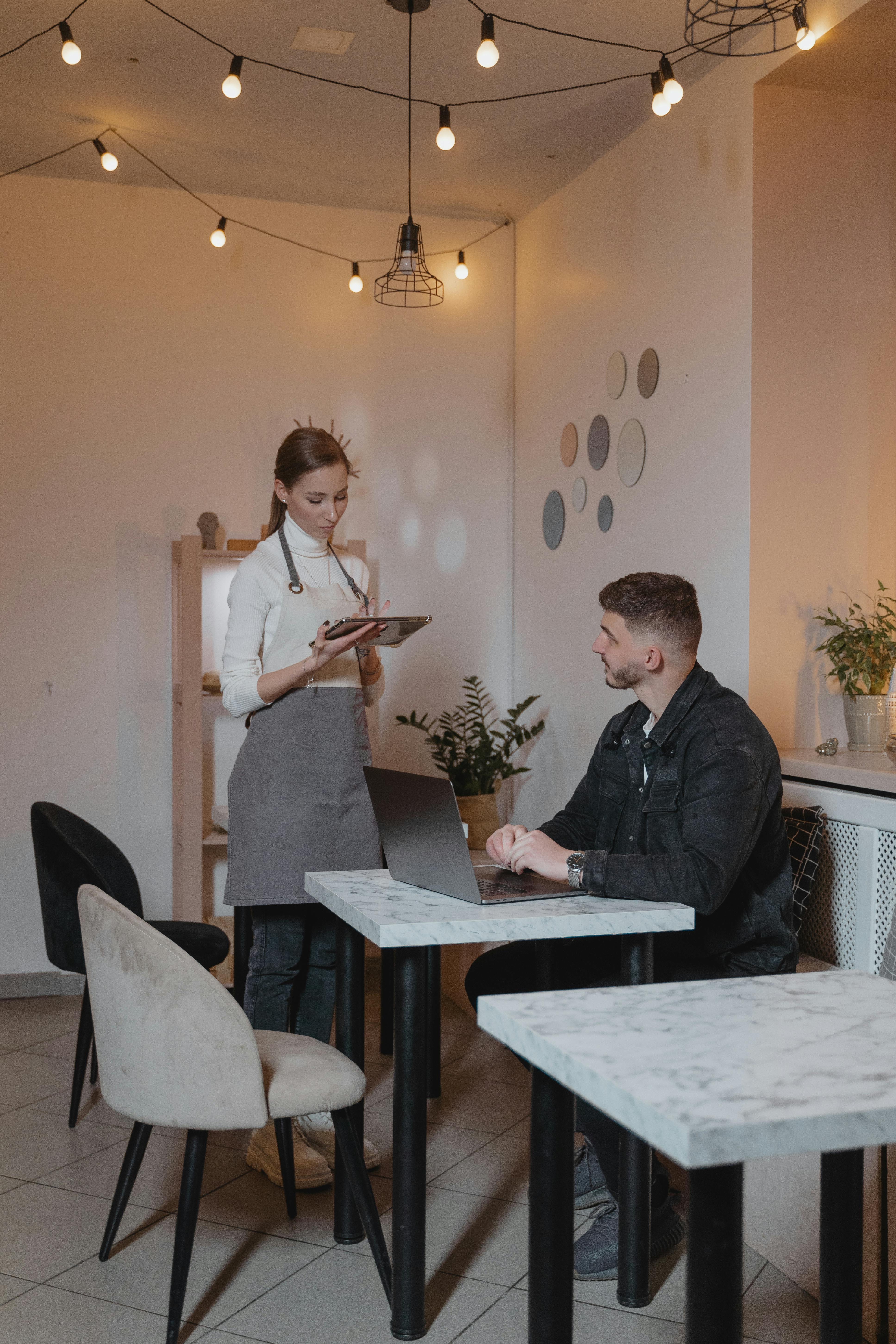 Camarera hablando con un cliente en un restaurante | Fuente: Pexels