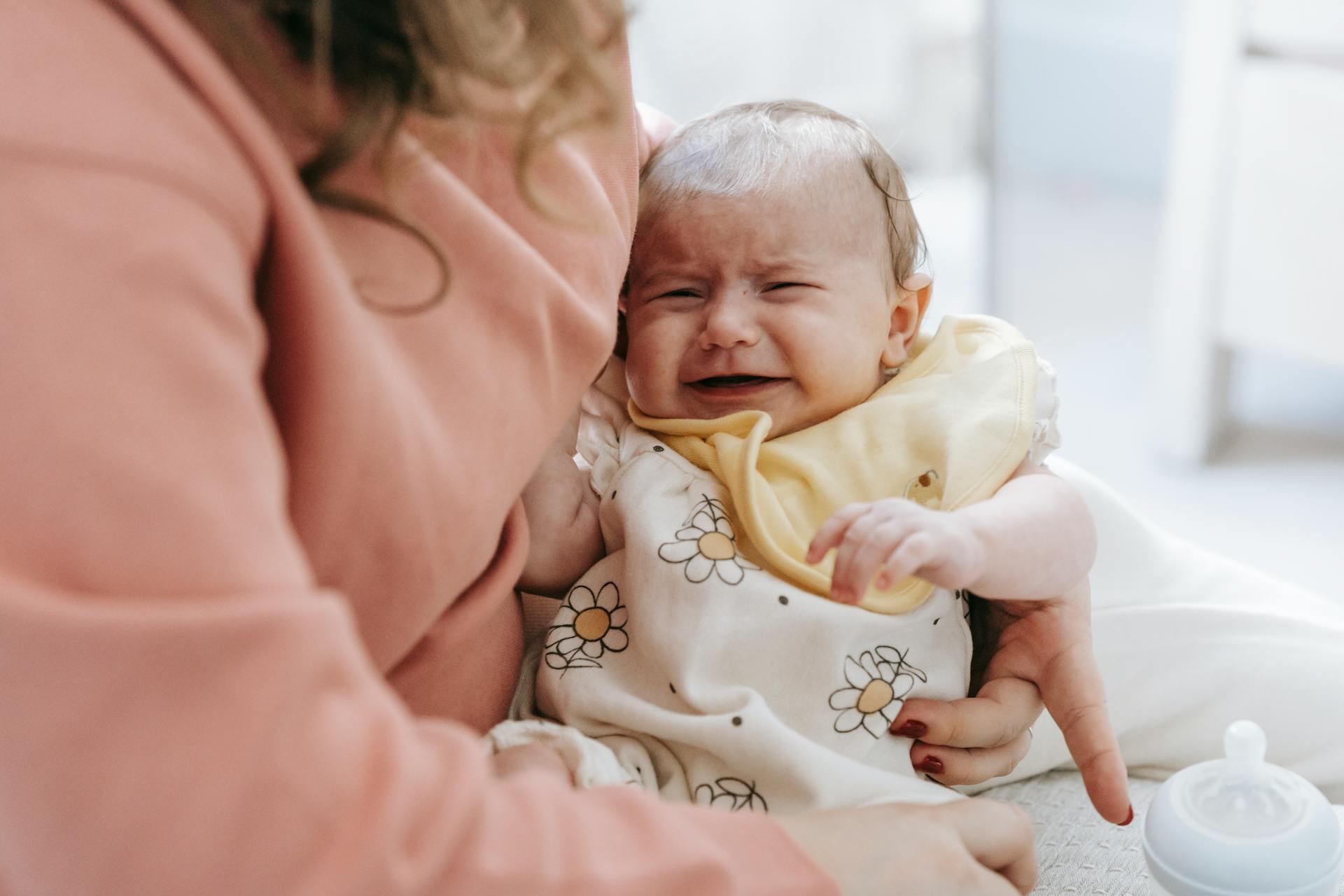 Una mujer con un bebé llorando en brazos | Fuente: Pexels