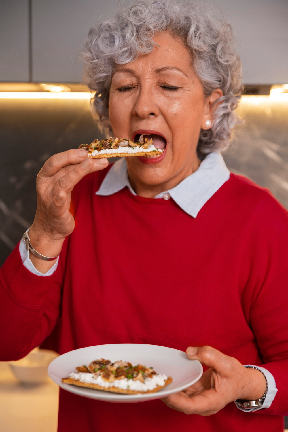Una mujer mayor comiendo | Fuente: Freepik