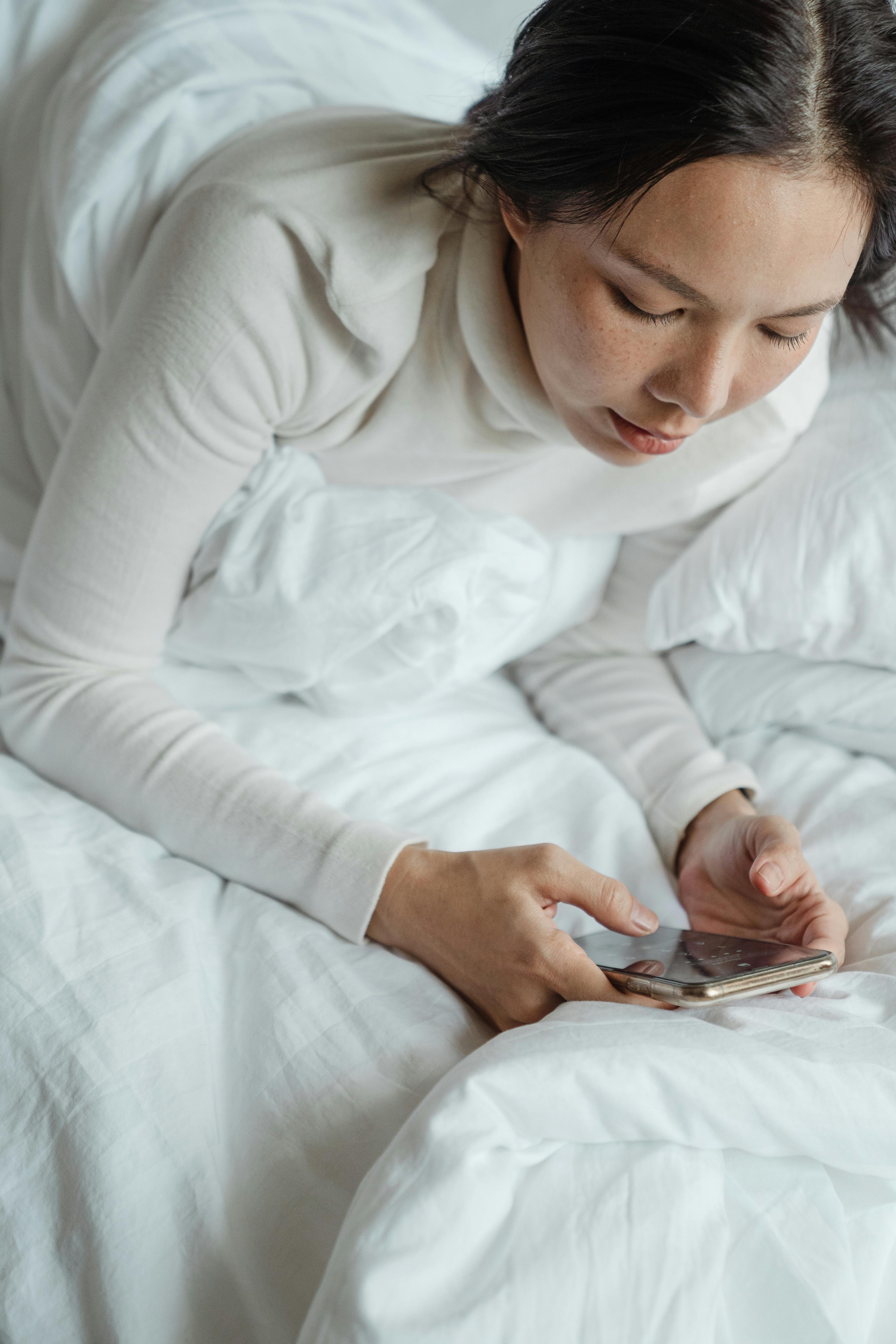 Una mujer infeliz mirando su teléfono | Fuente: Pexels