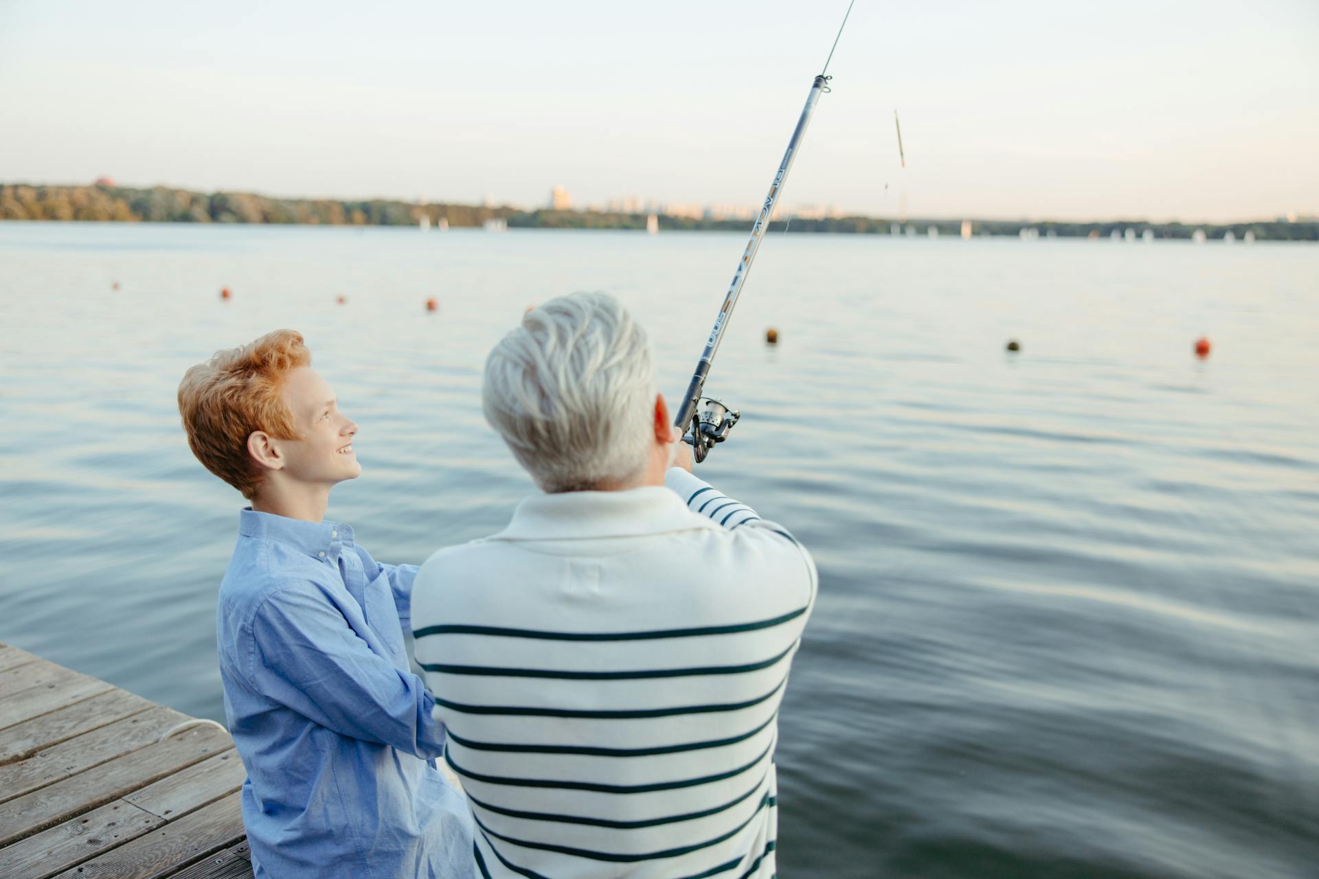 Un anciano y un niño pescando junto al muelle | Fuente: Pexels