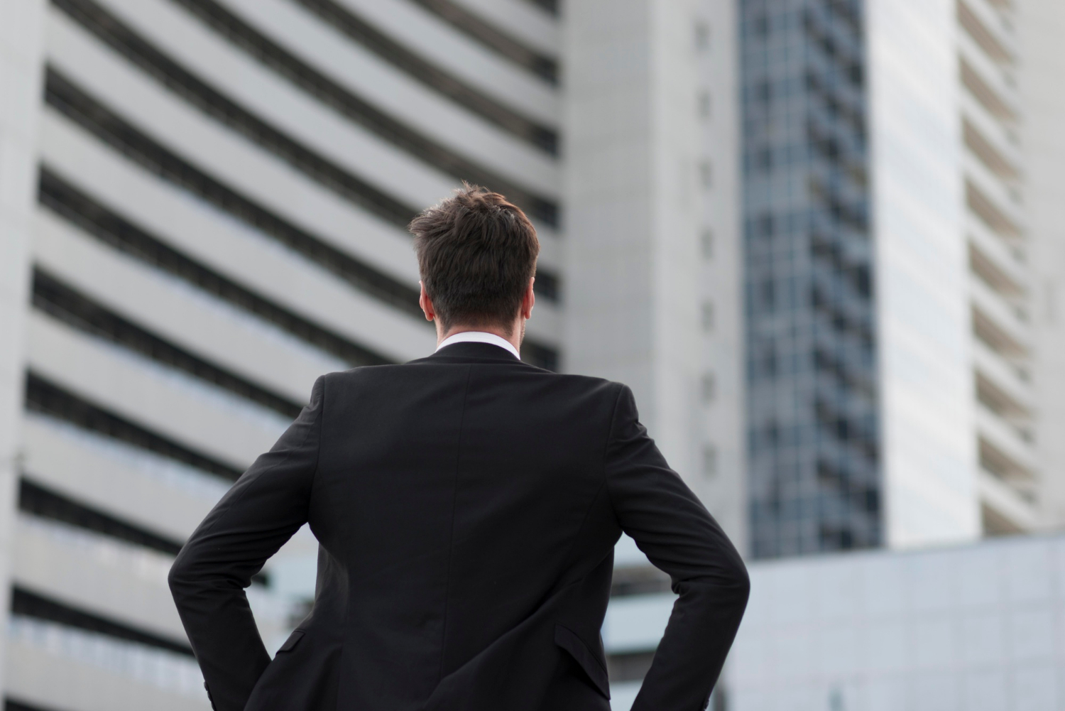 Vista trasera de un hombre con traje negro | Fuente: Freepik