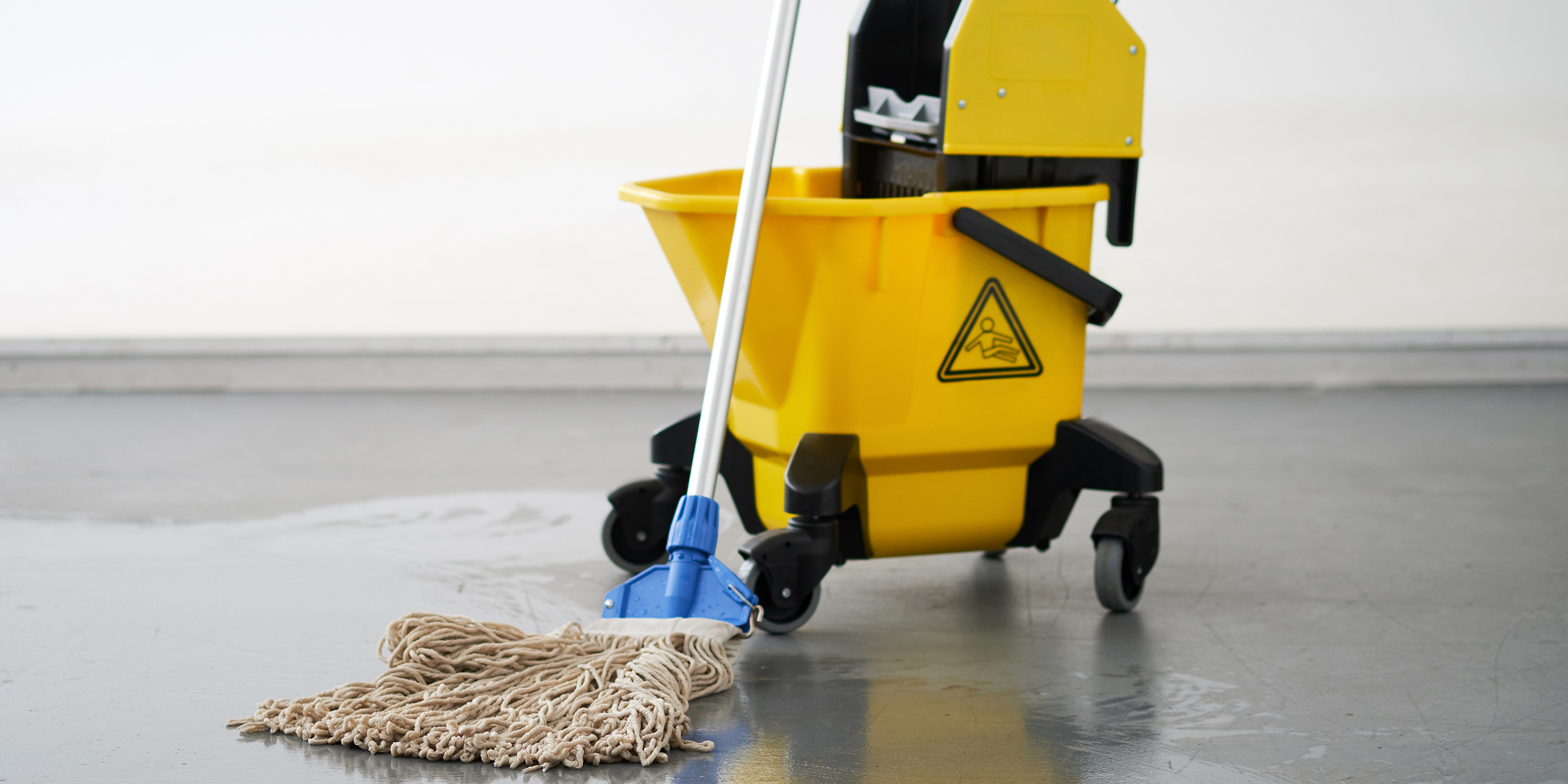 Fregona y cubo en el suelo | Fuente: Shutterstock