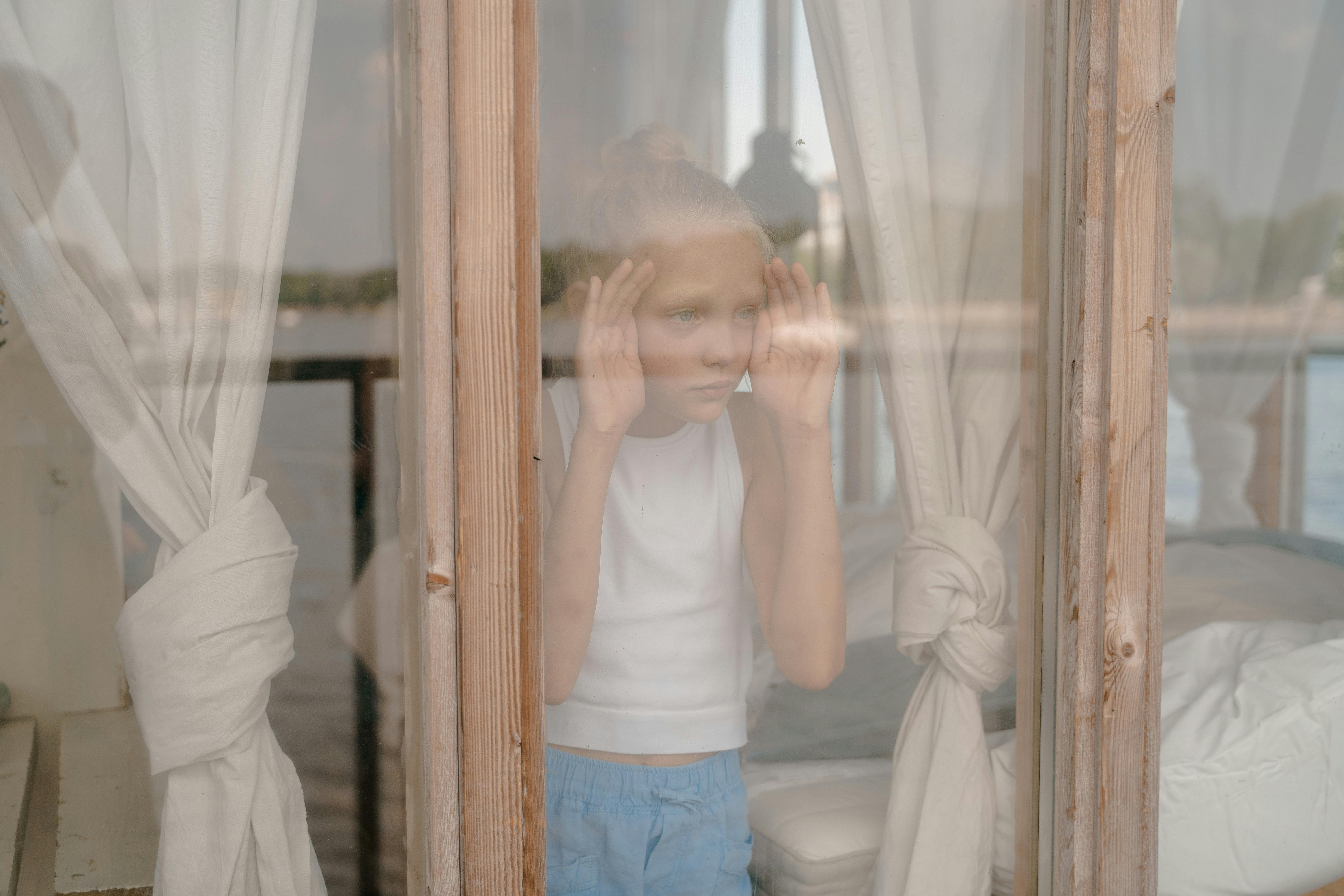Un niño mirando por una ventana | Fuente: Pexels