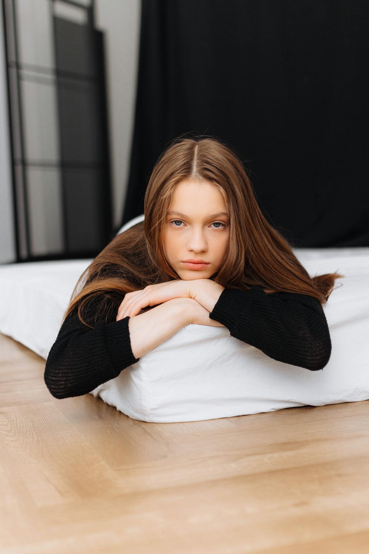 Una adolescente tumbada en un colchón | Fuente: Pexels