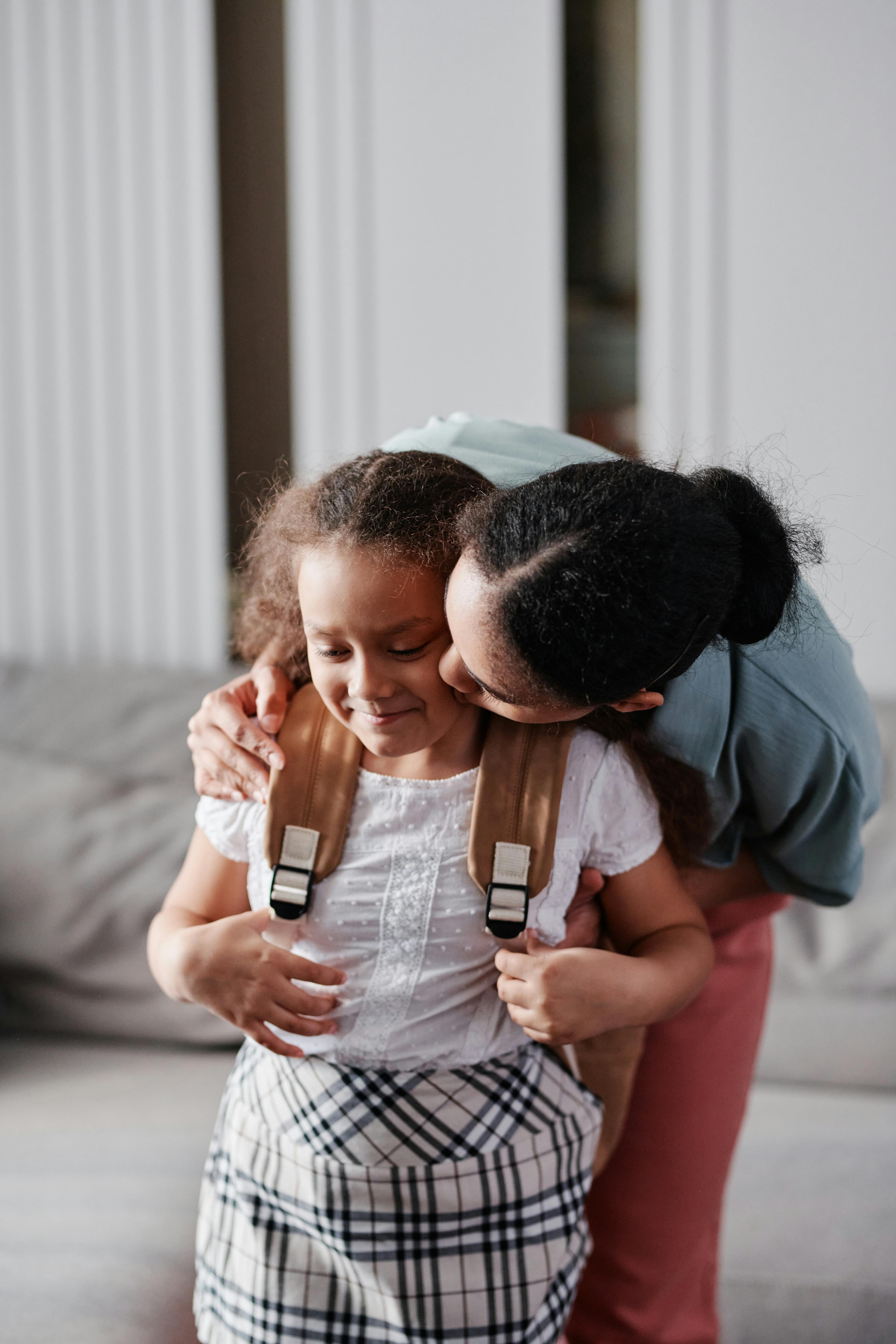 Una madre besando a su hija | Fuente: Pexels