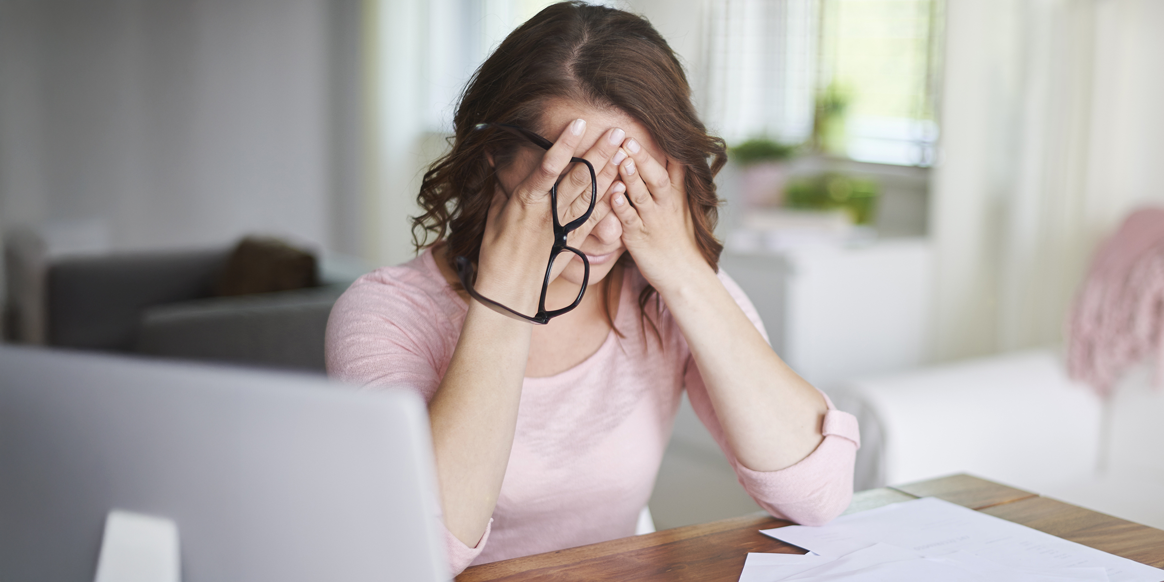 Una mujer preocupada sentada con la cabeza entre las manos | Fuente: Shutterstock