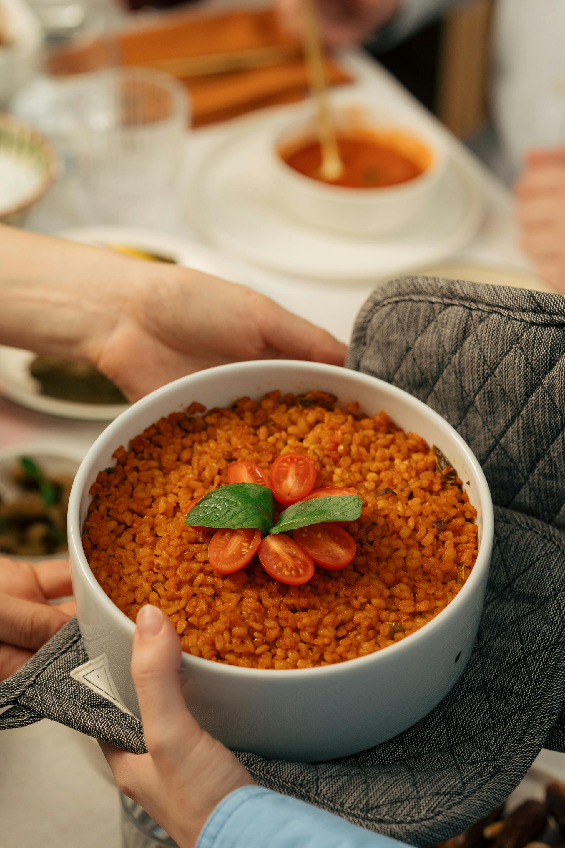 Dos manos sosteniendo un cuenco de pilaf de tomate | Fuente: Pexels