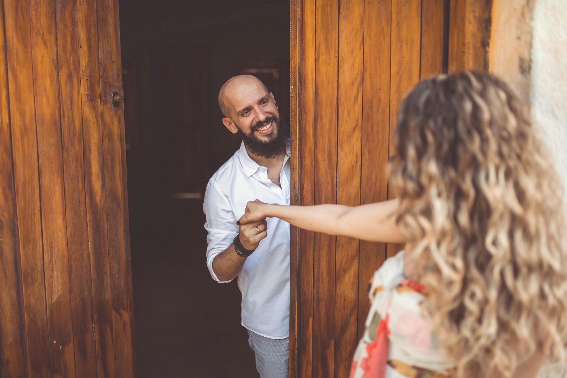 Un hombre feliz recibiendo a una mujer en su casa | Fuente: Pexels