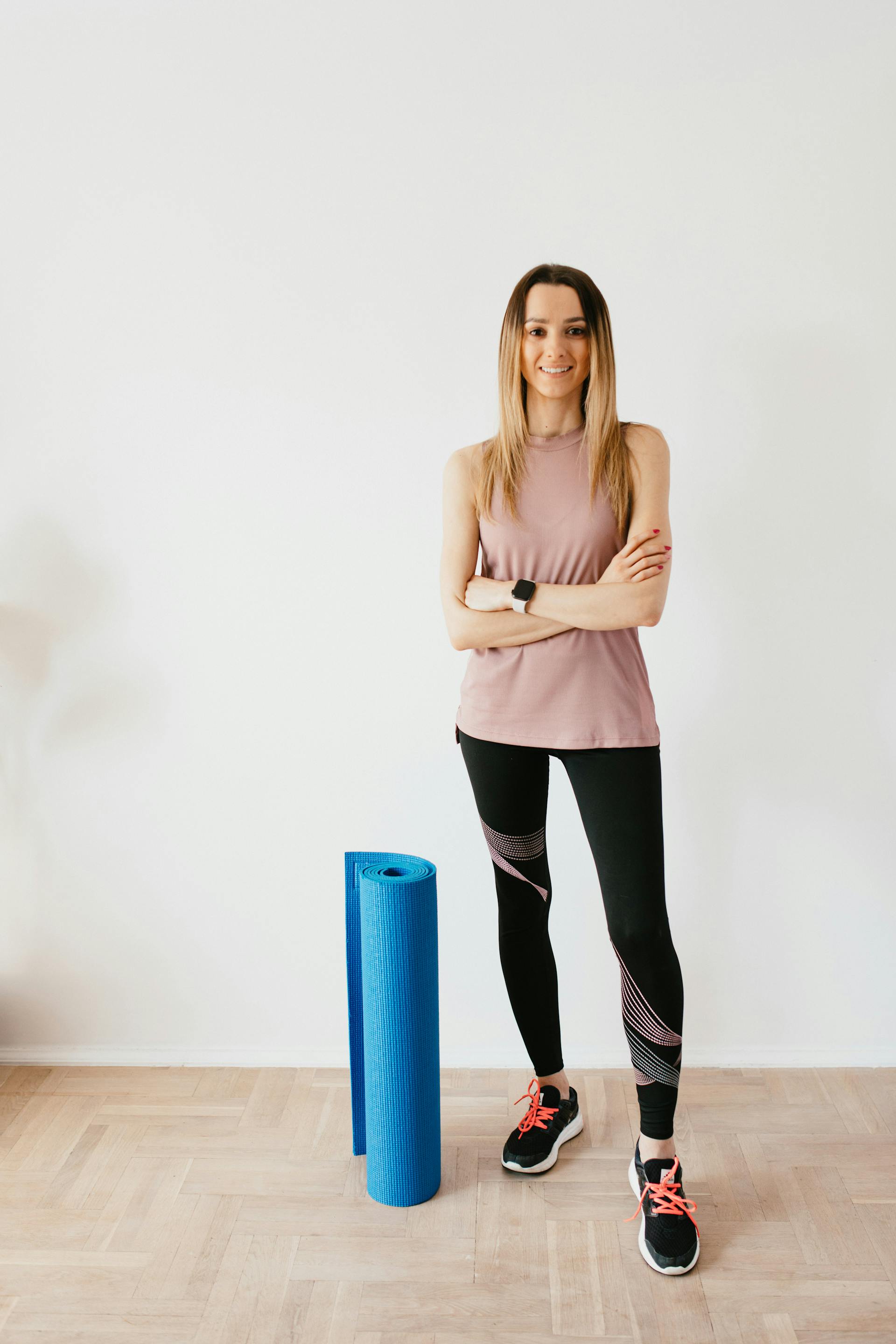 Una instructora de fitness junto a una esterilla de yoga doblada | Fuente: Pexels