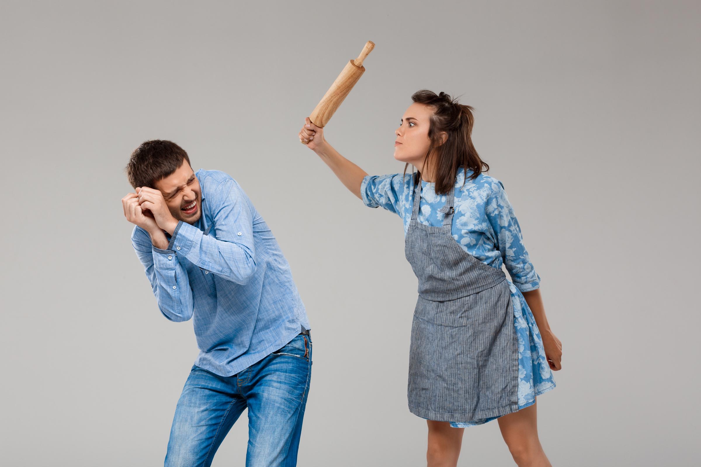 Una mujer amenaza a un hombre acobardado | Fuente: Freepik