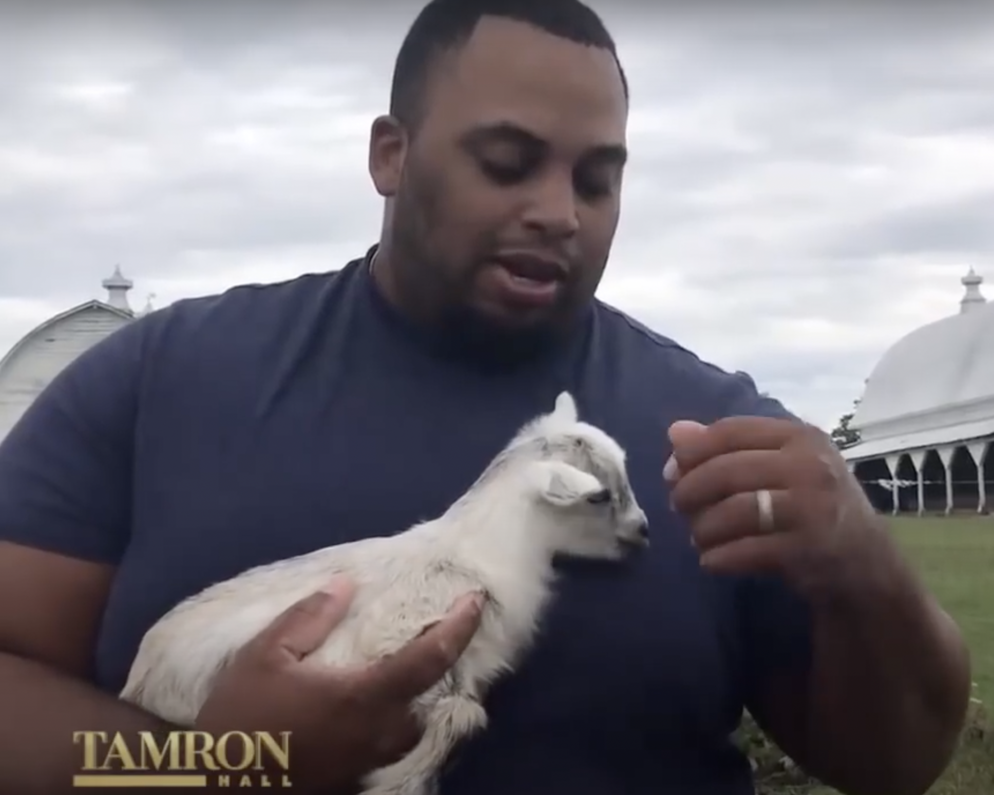 El atleta fotografiado mientras sujetaba una cabra bebé | Fuente: YouTube/TamronHallShow