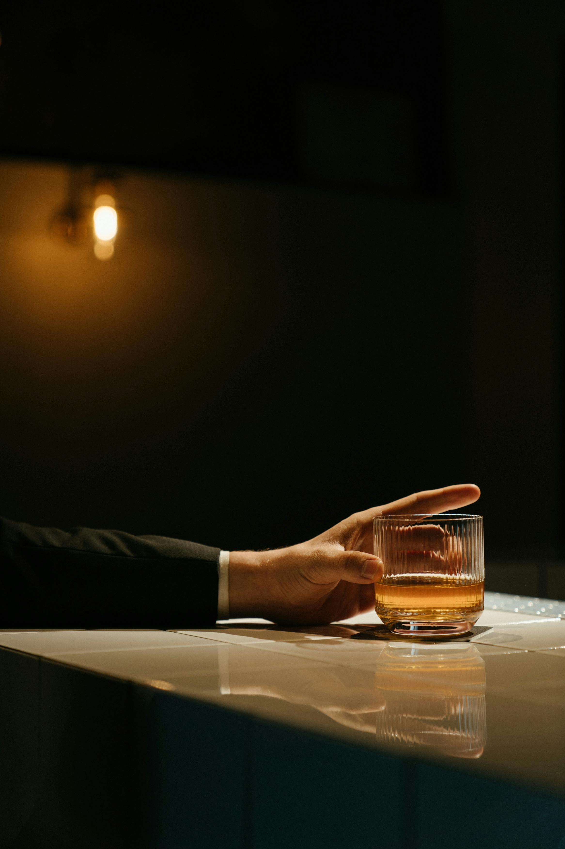 Un hombre con una copa en la mano en un bar | Fuente: Pexels