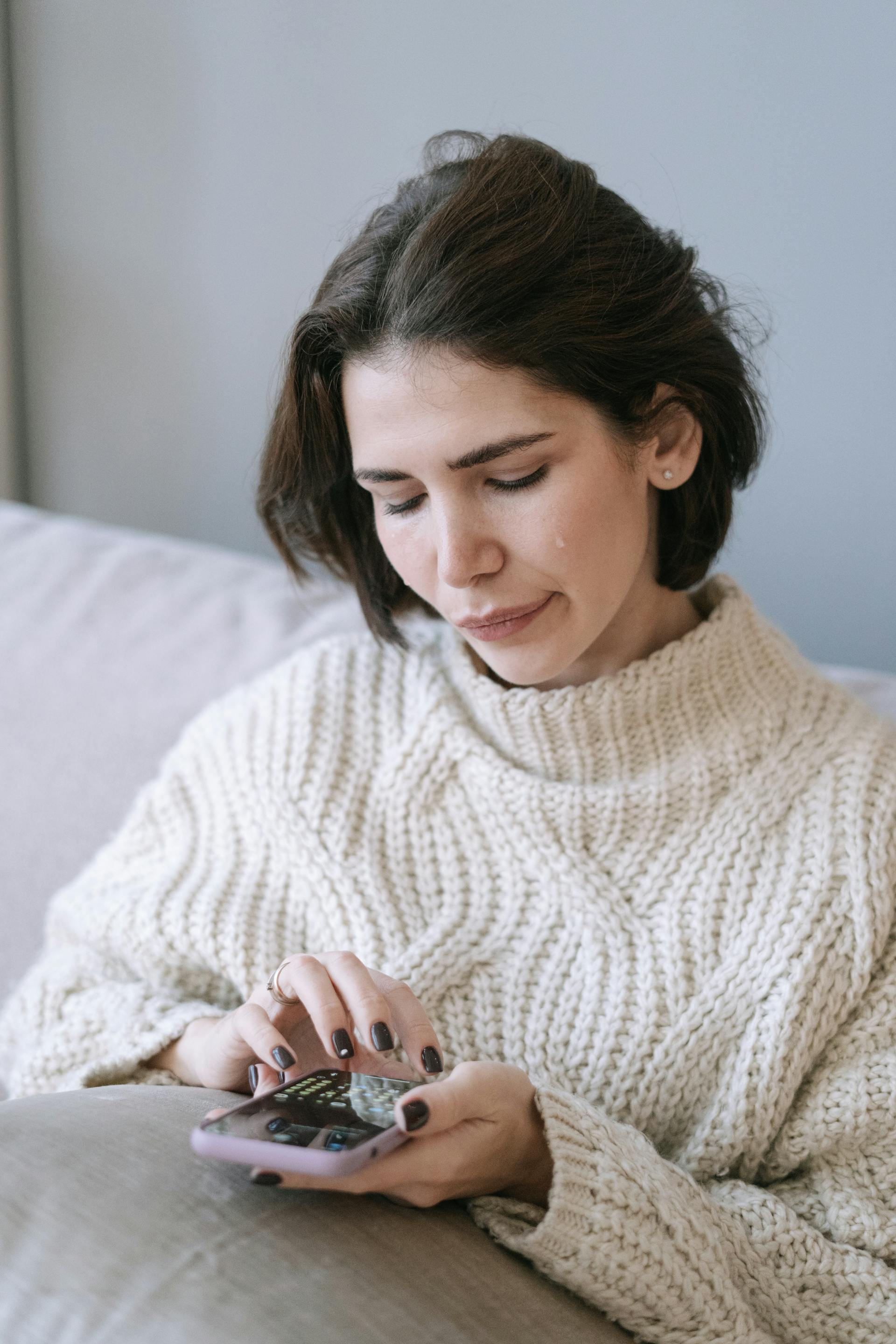 Una mujer llorando con un móvil en la mano | Fuente: Pexels