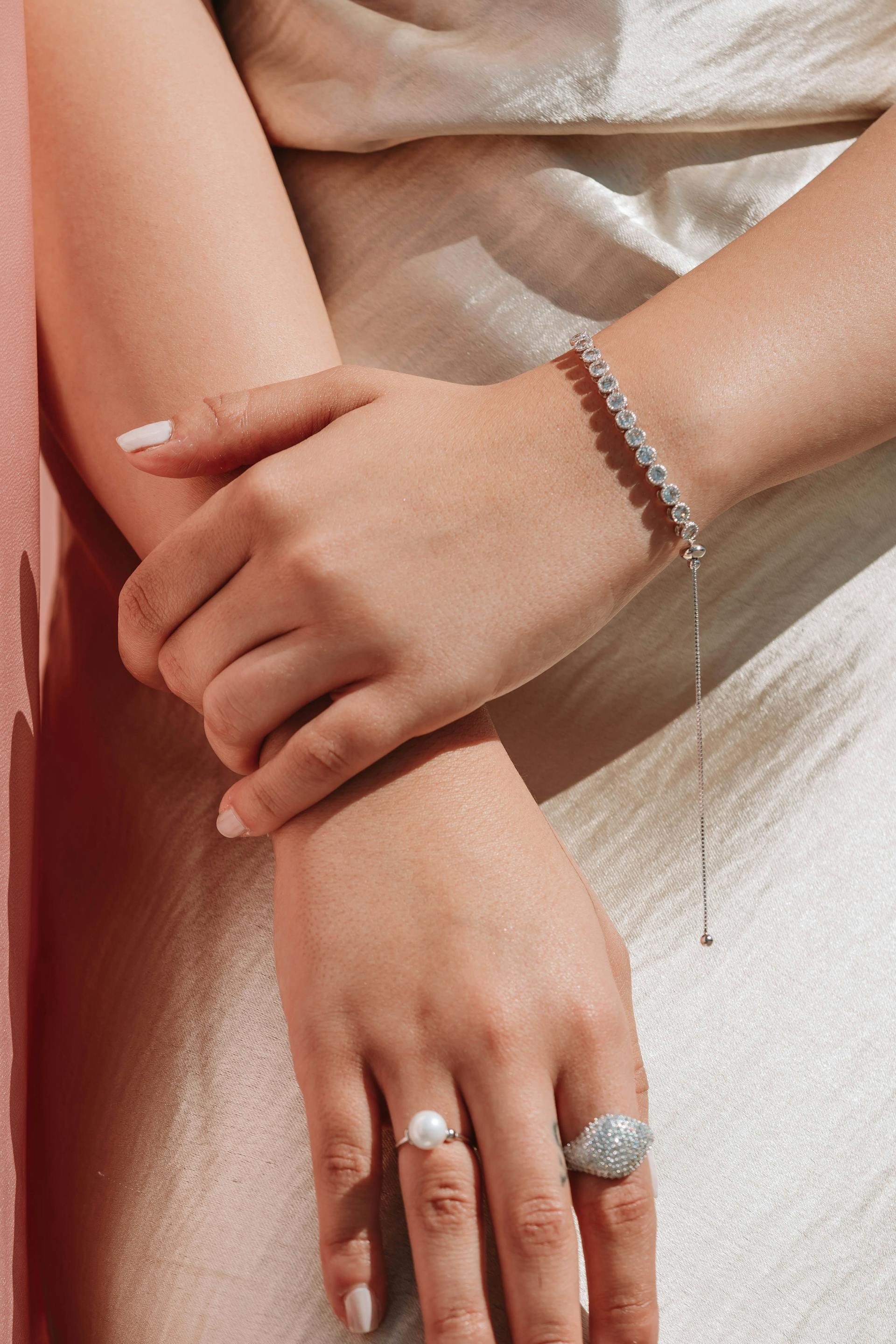 Primer plano de una mujer con una pulsera y anillos | Fuente: Pexels