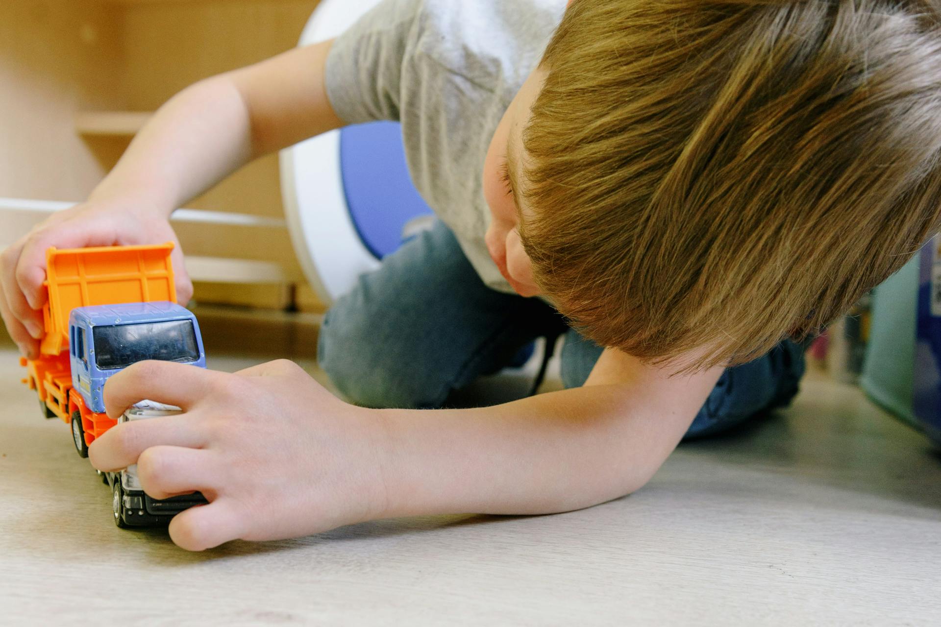 Niño jugando con un camión de juguete | Fuente: Pexels