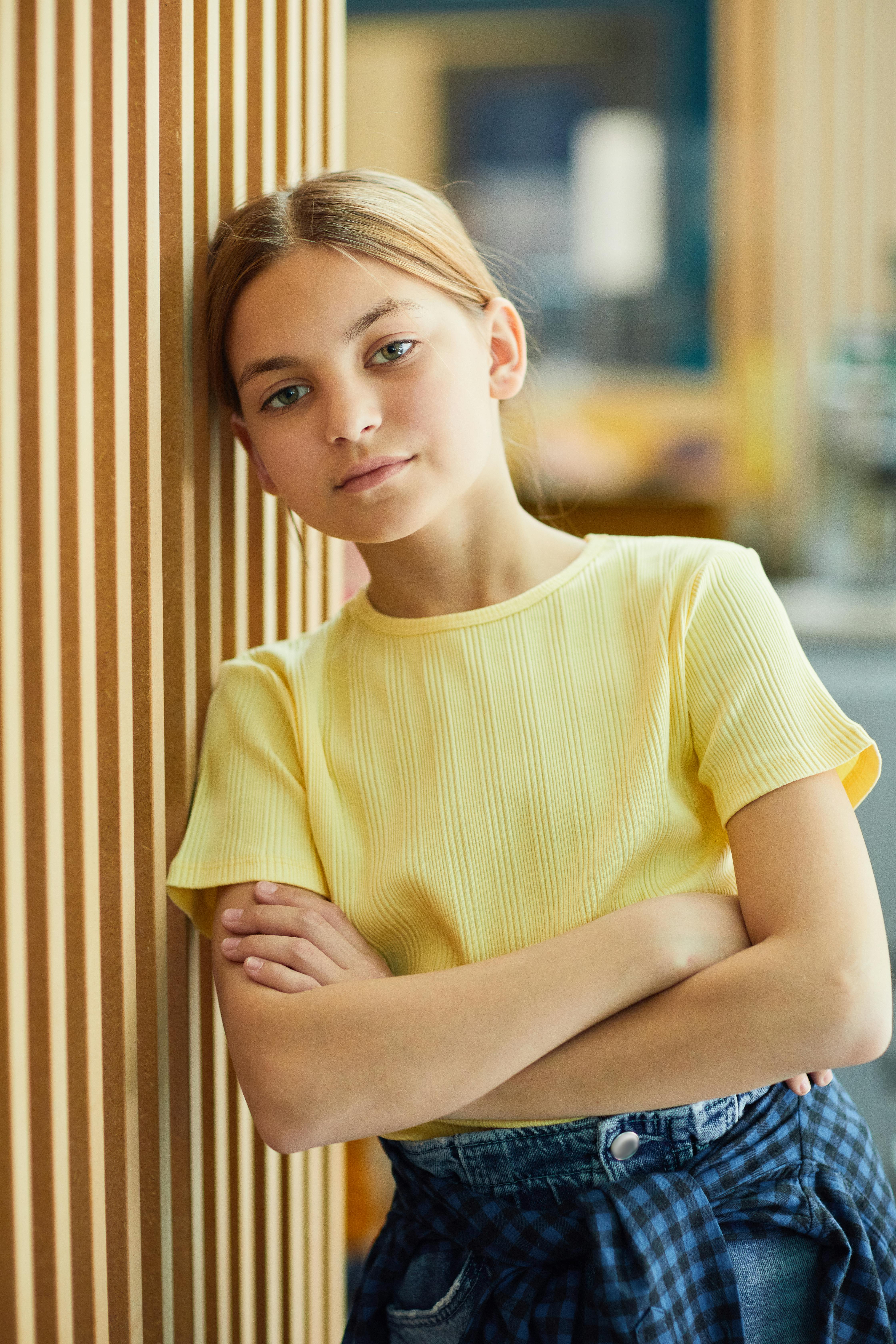 Una chica seria apoyada en una pared | Fuente: Pexels