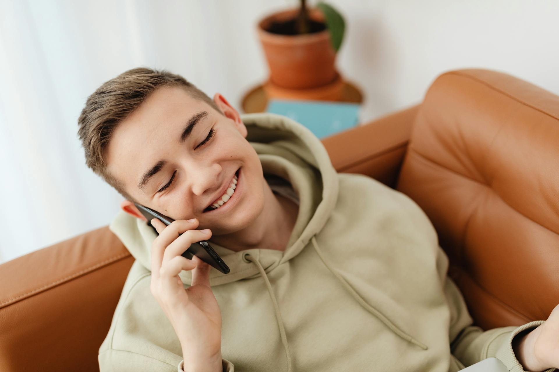 Un adolescente encantado hablando por teléfono | Fuente: Pexels
