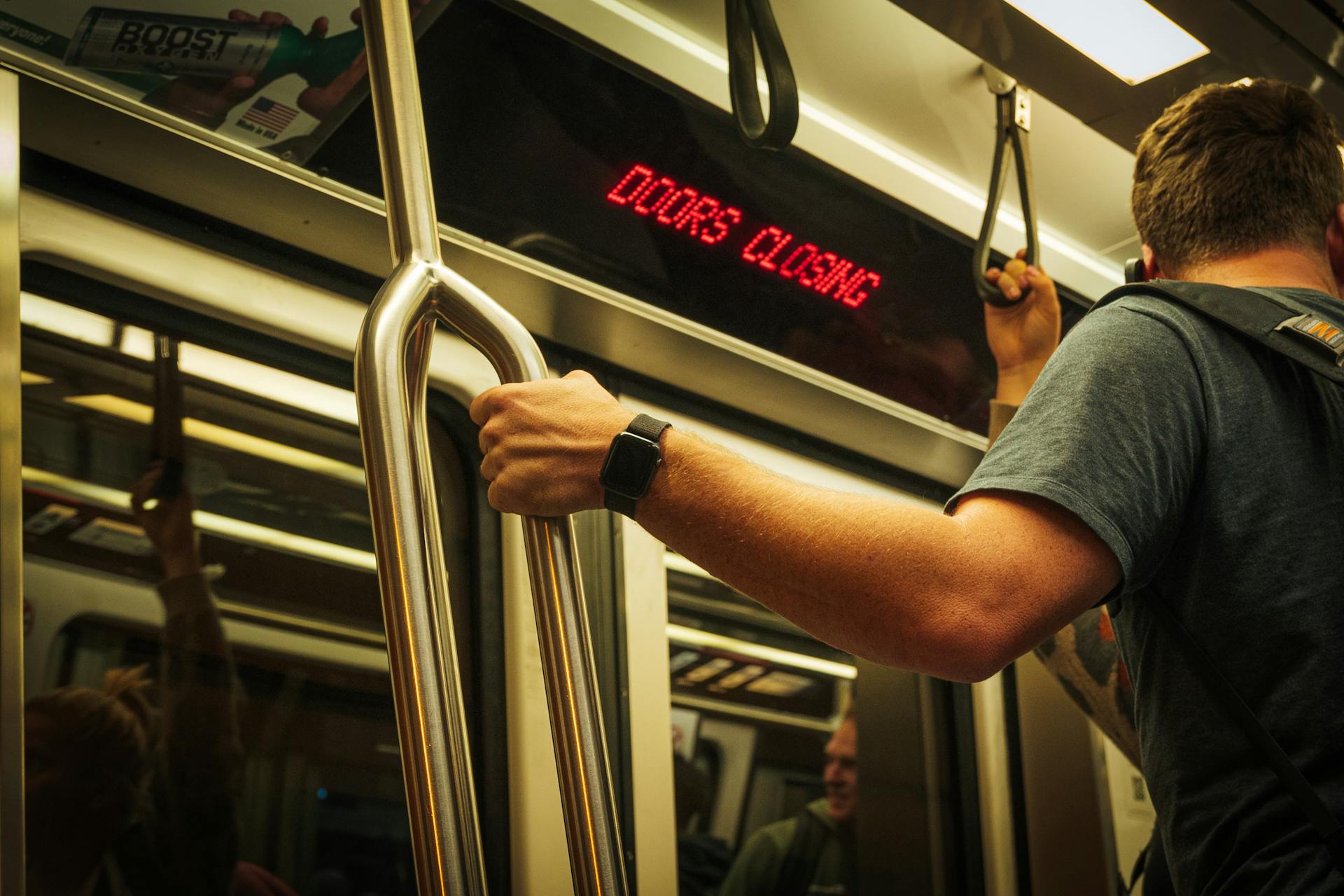 Un joven de pie en el metro | Fuente: Pexels