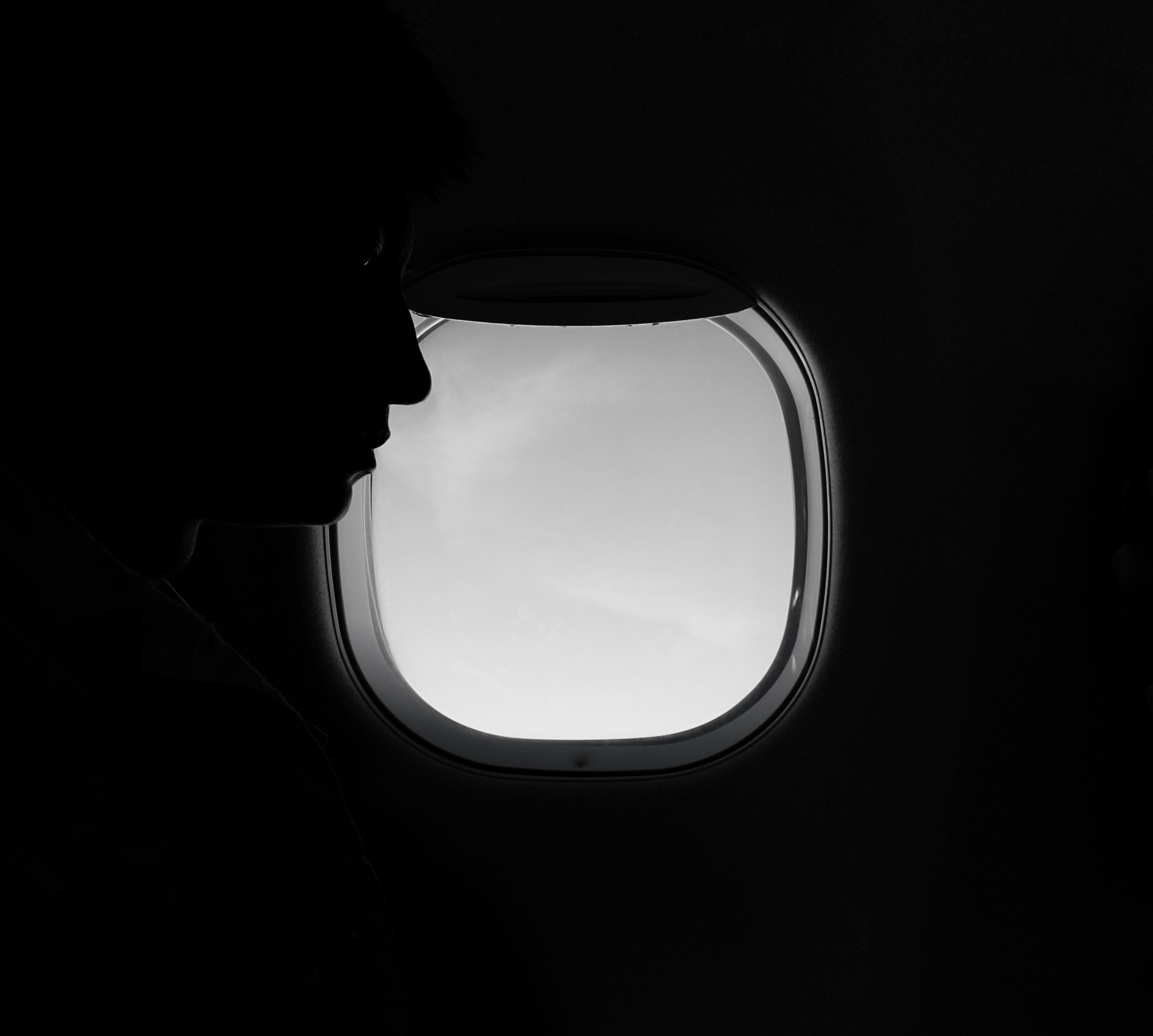 Una mujer mirando el asiento que tiene delante en un avión | Fuente: Unsplash