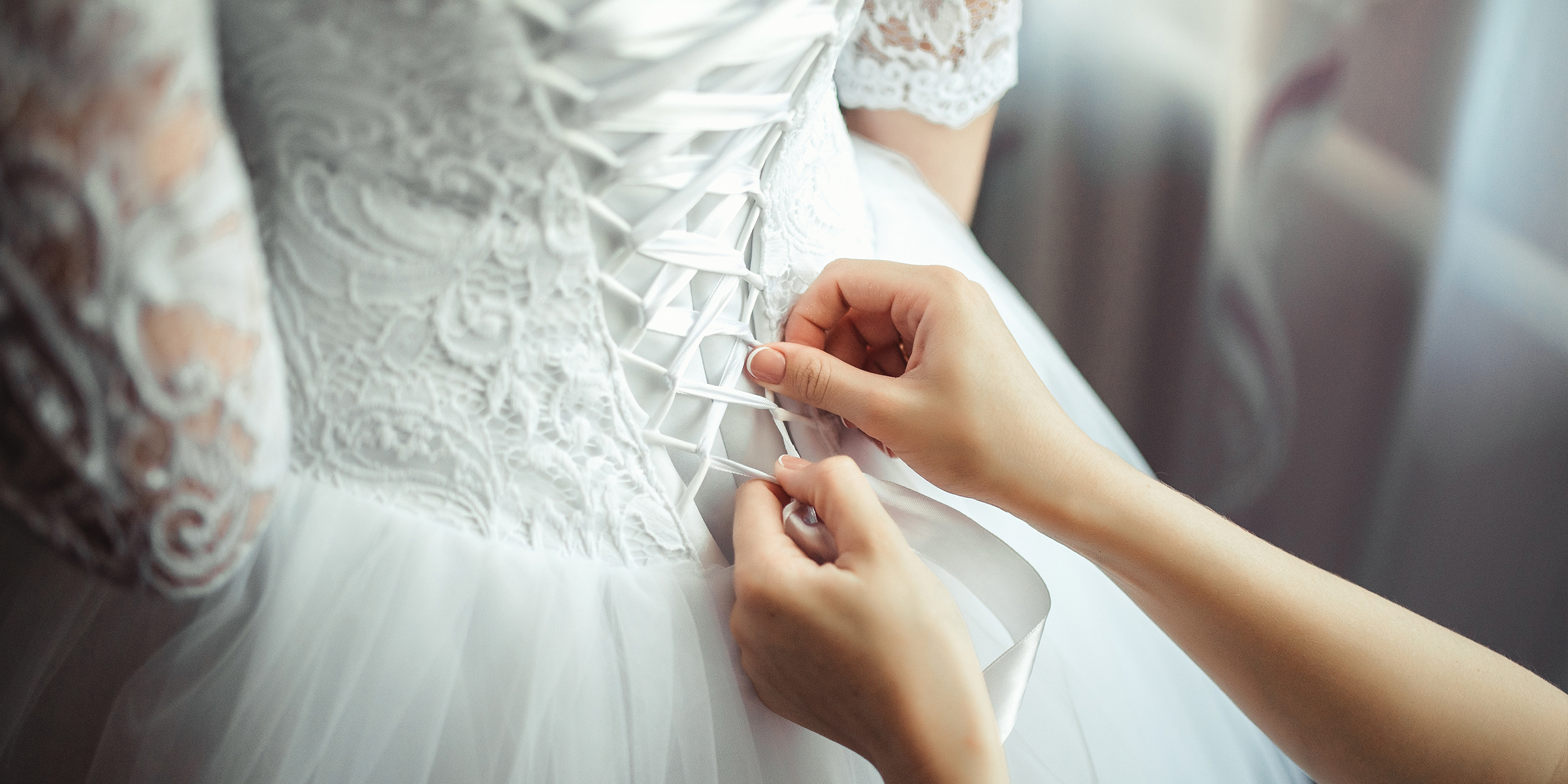 Alguien ayuda con el vestido de la novia | Fuente: Shutterstock