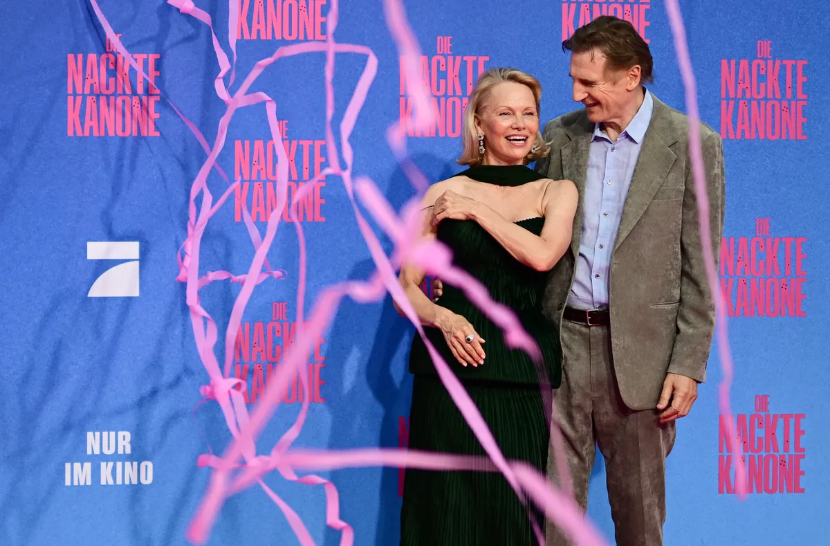 Pamela Anderson y Liam Neeson comparten una risa en la alfombra roja del estreno de "The Naked Gun" el 24 de julio de 2025 en Berlín, Alemania.