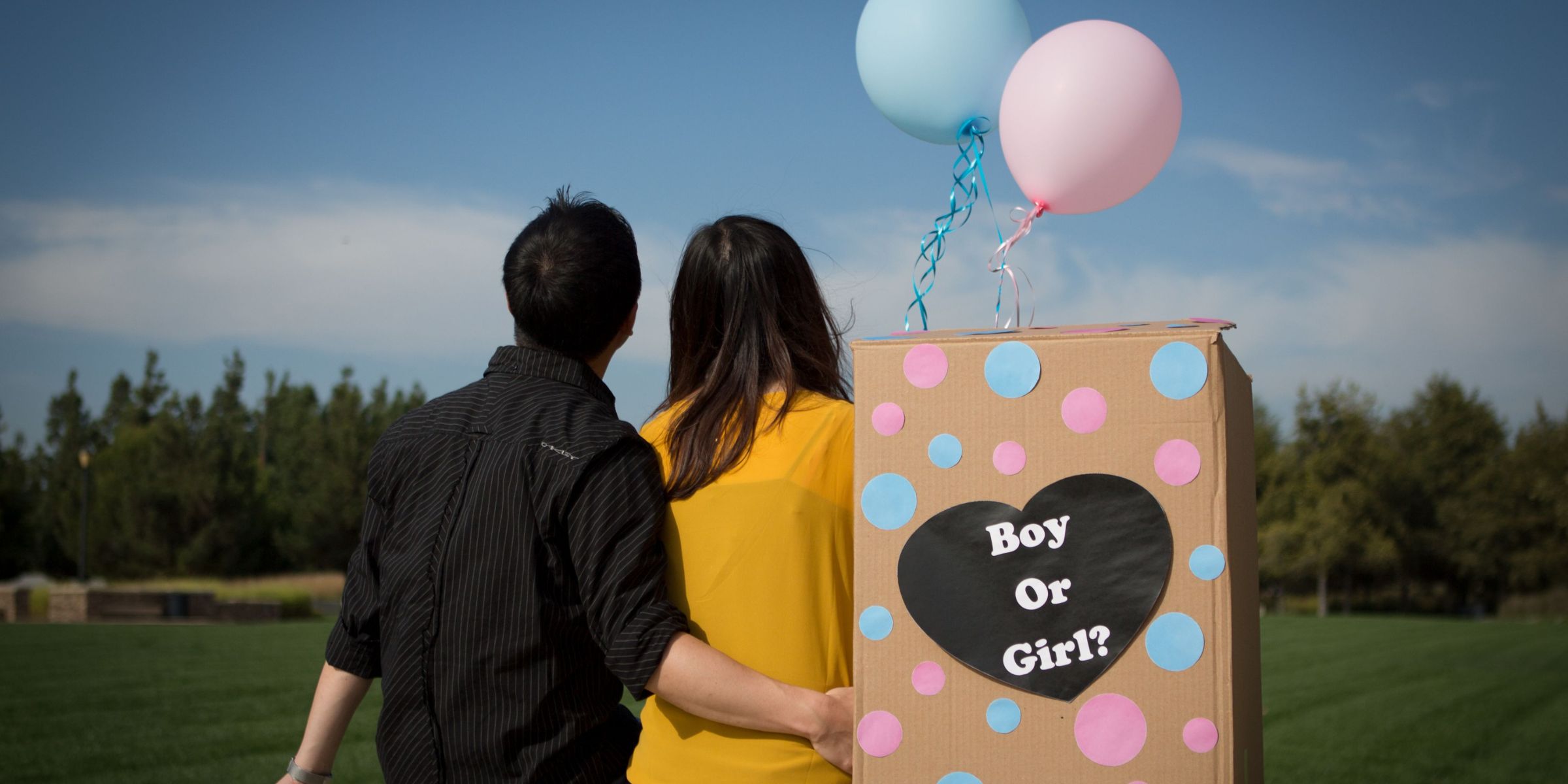 A couple sitting with a gender-reveal box | Source: Pexels