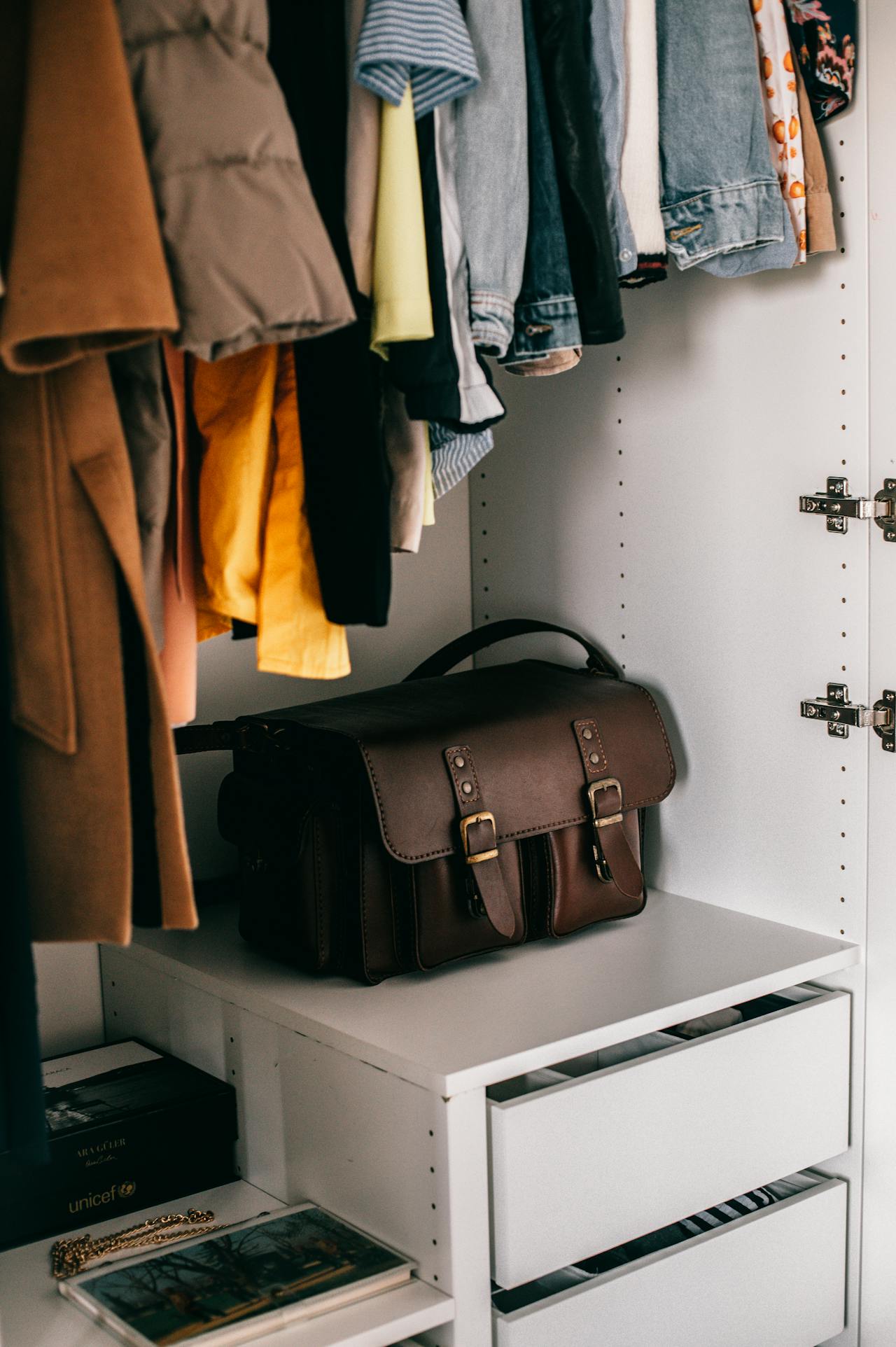Una bolsa y ropa en un armario | Fuente: Pexels