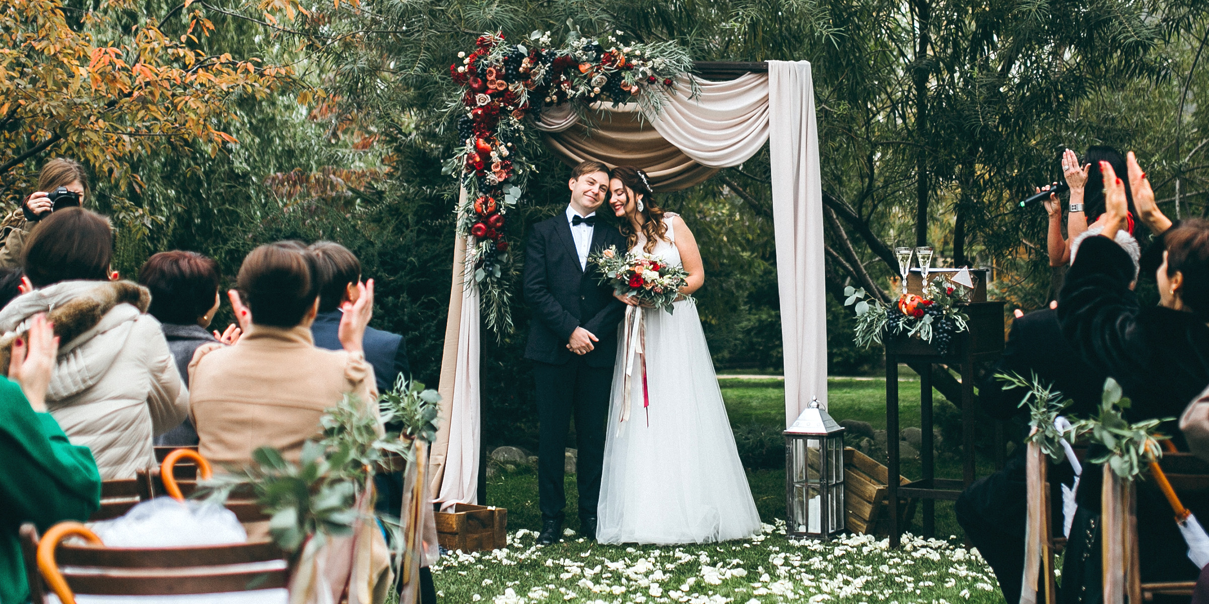 Una pareja de novios bajo un arco floral | Fuente: Shutterstock