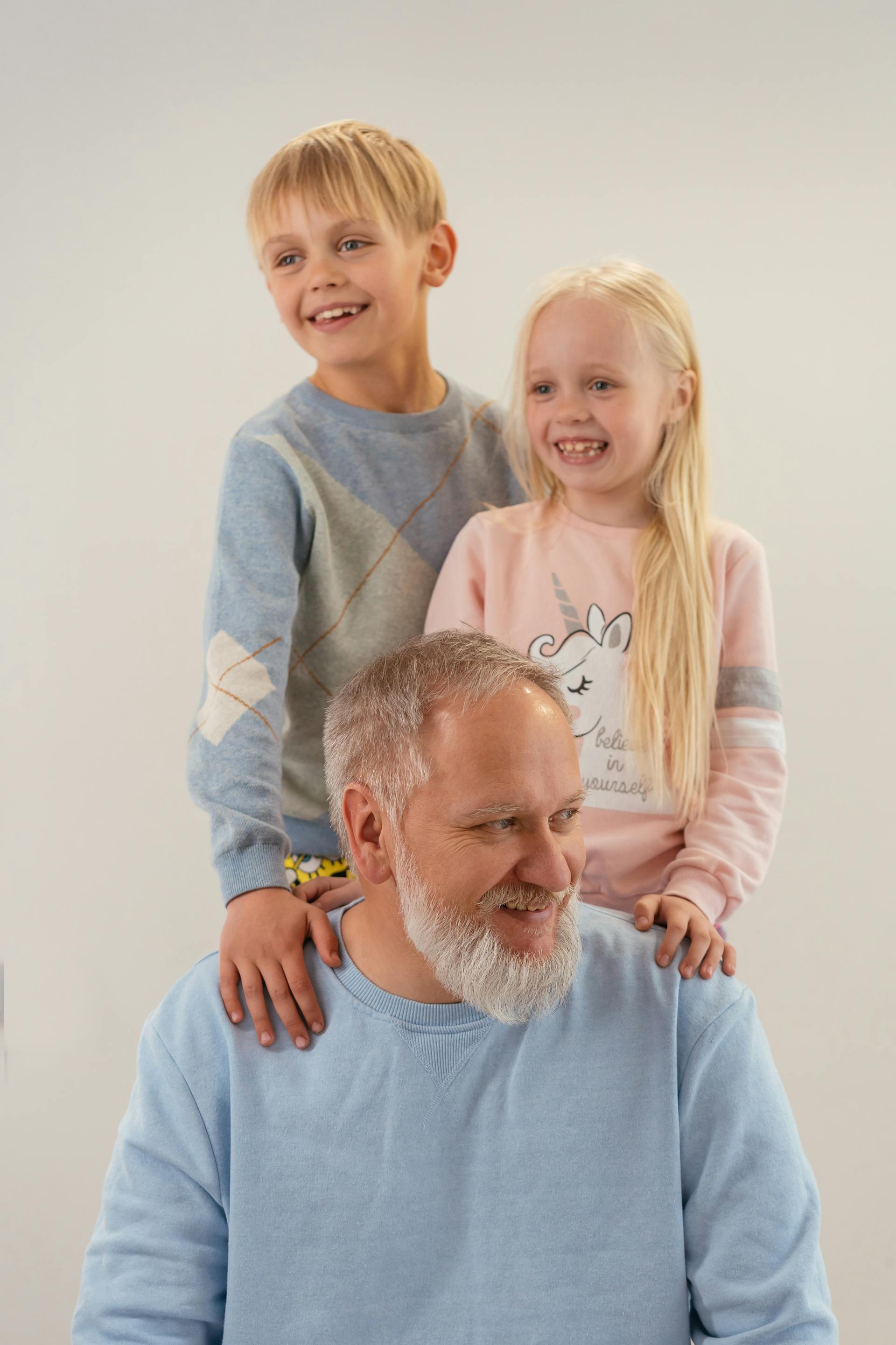 Un hombre feliz con dos hijos | Fuente: Pexels