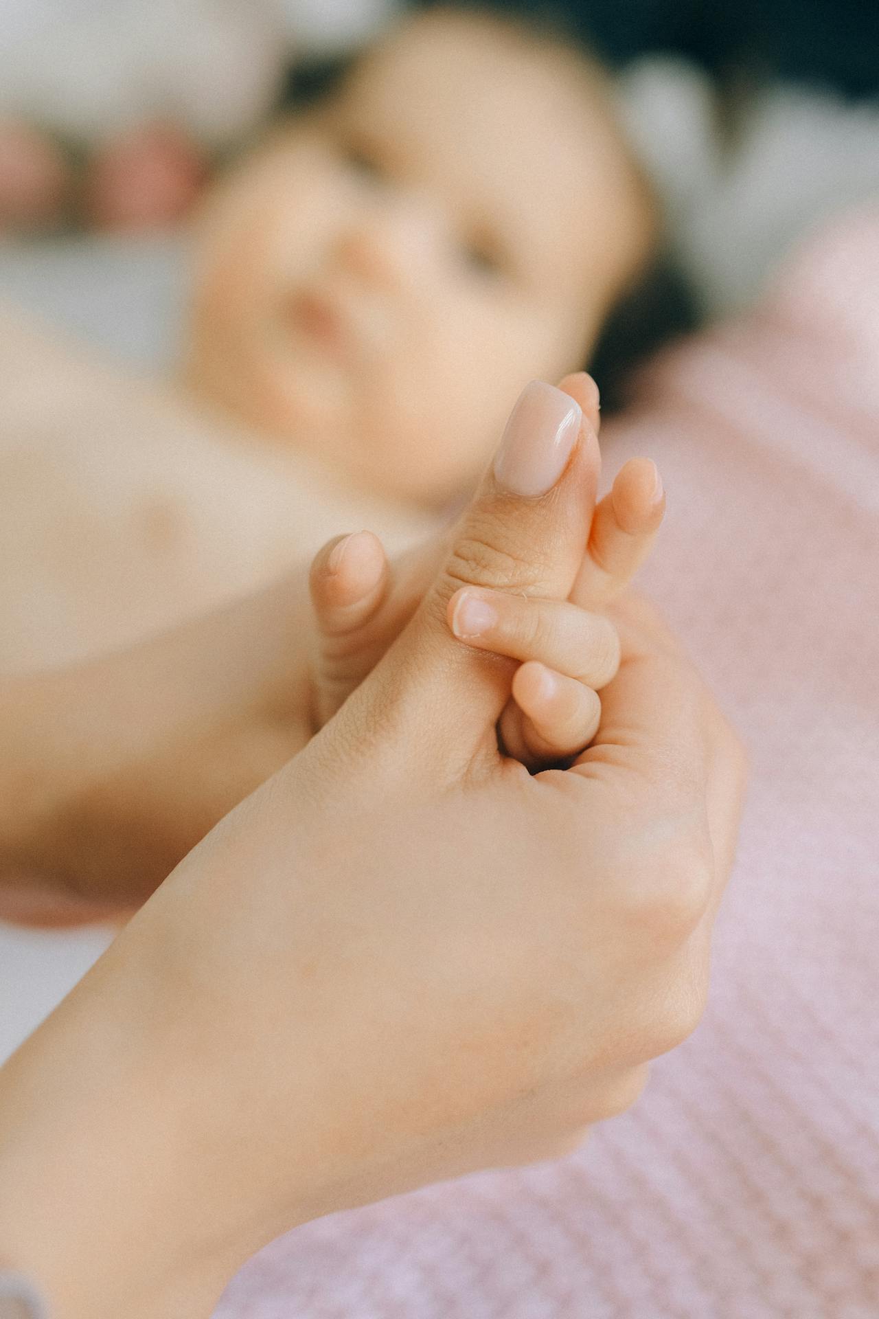 Una mujer cogiendo de la mano a un bebé | Fuente: Pexels