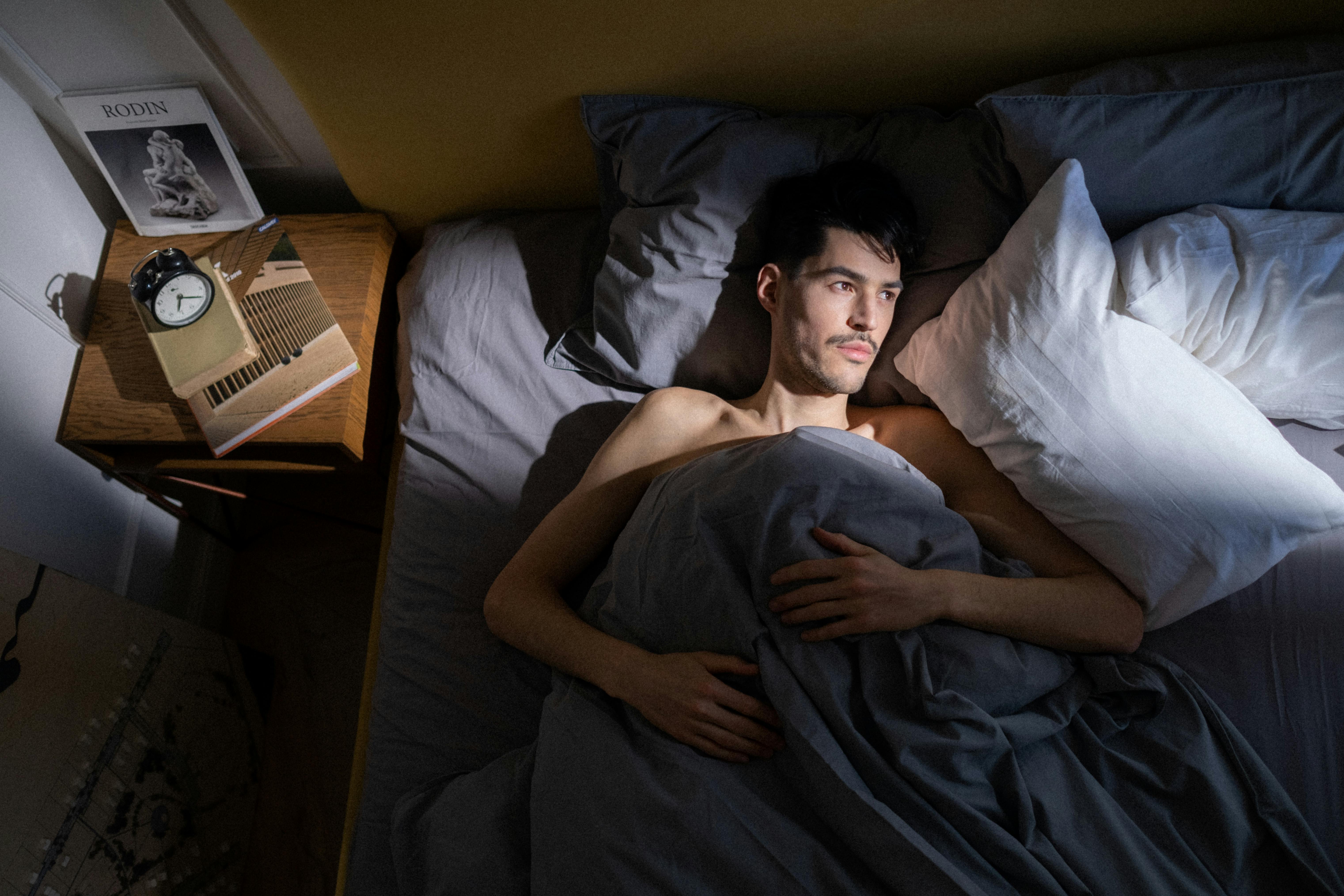 Hombre tumbado en la cama | Fuente: Pexels
