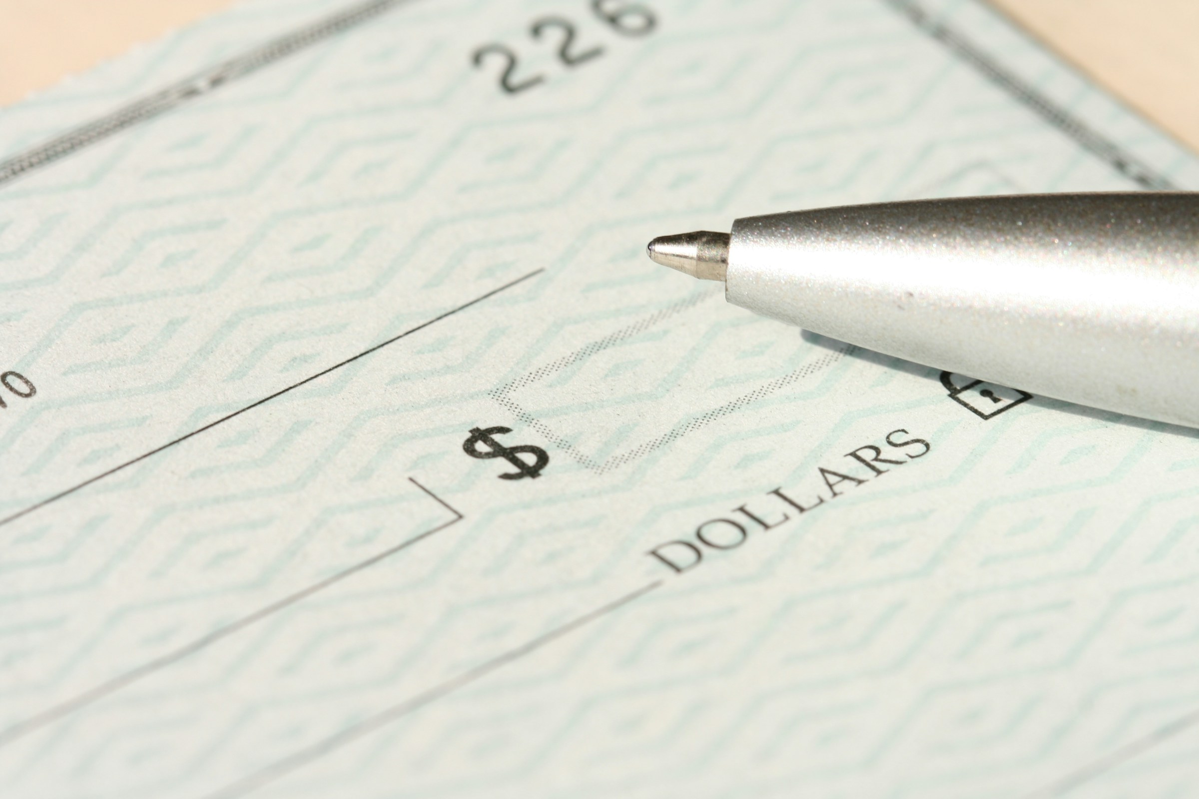 Bolígrafo encima de un cheque bancario | Fuente: Unsplash