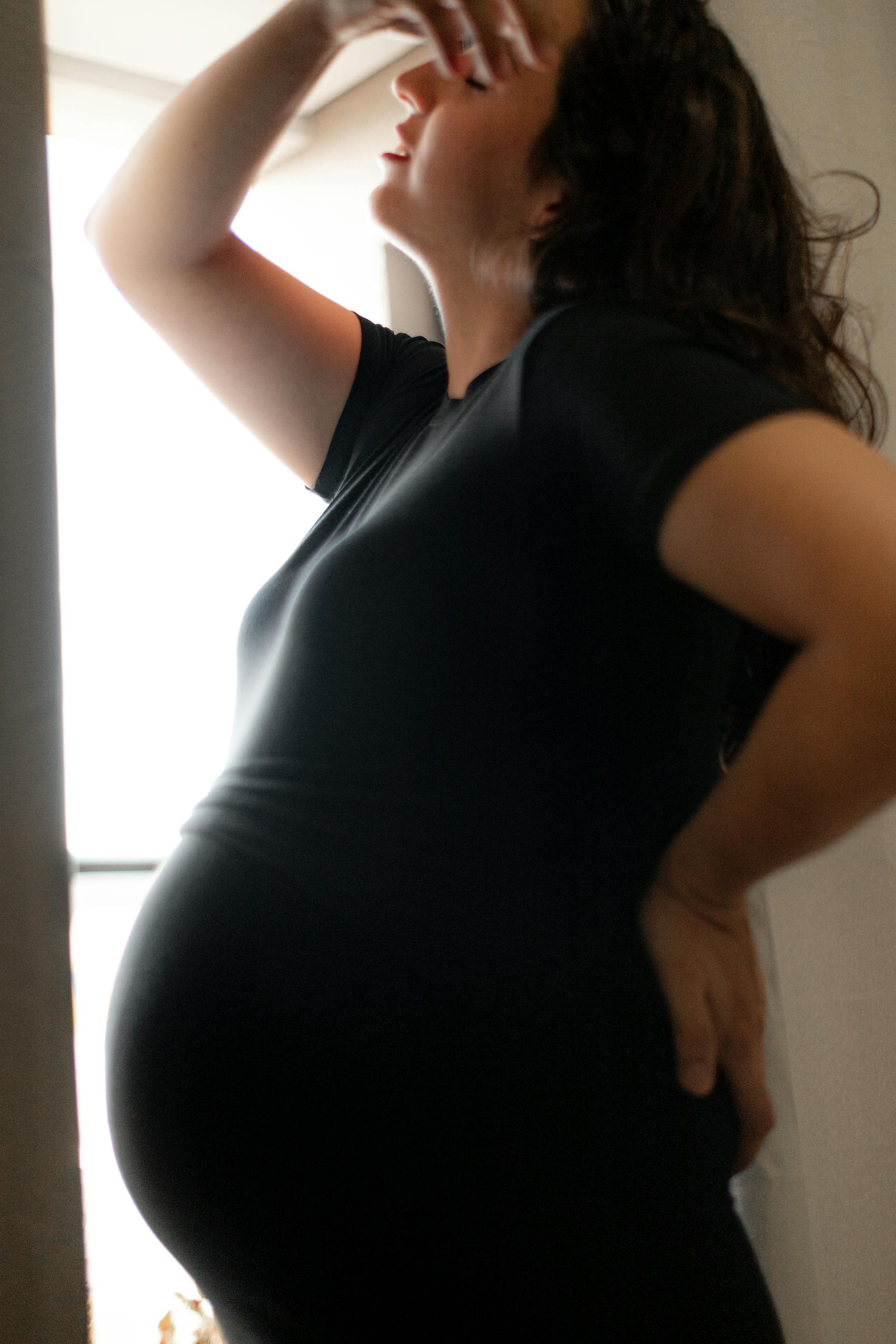 Una mujer embarazada angustiada junto a la ventana | Fuente: Pexels