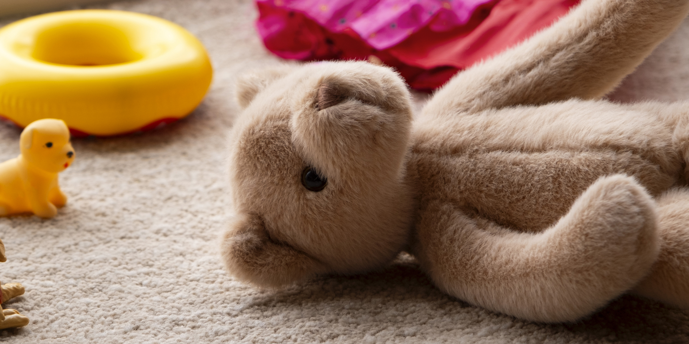 Un osito de peluche tumbado en un suelo enmoquetado | Fuente: Freepik