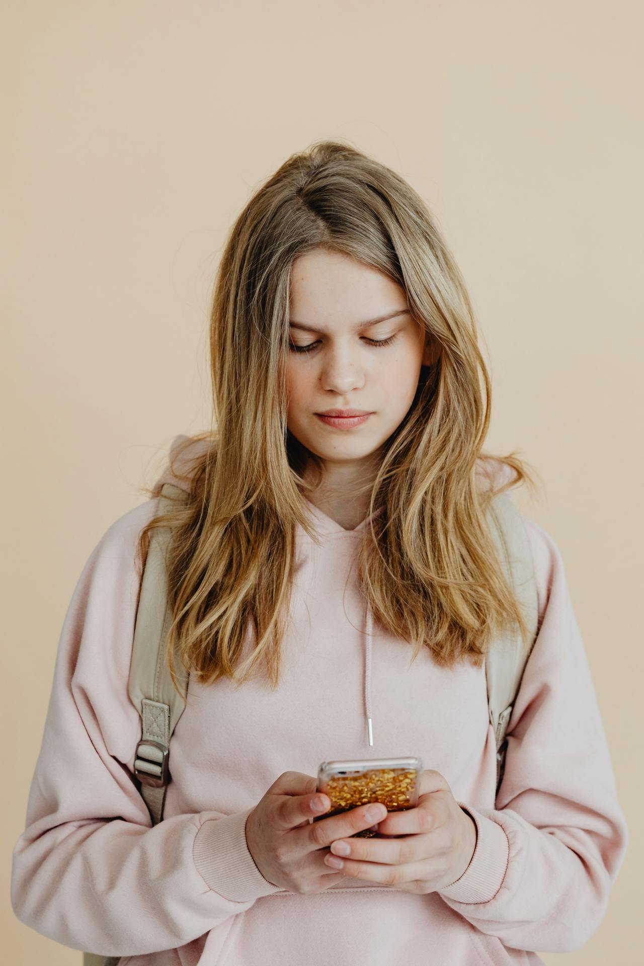 Una adolescente sujetando su teléfono | Fuente: Pexels