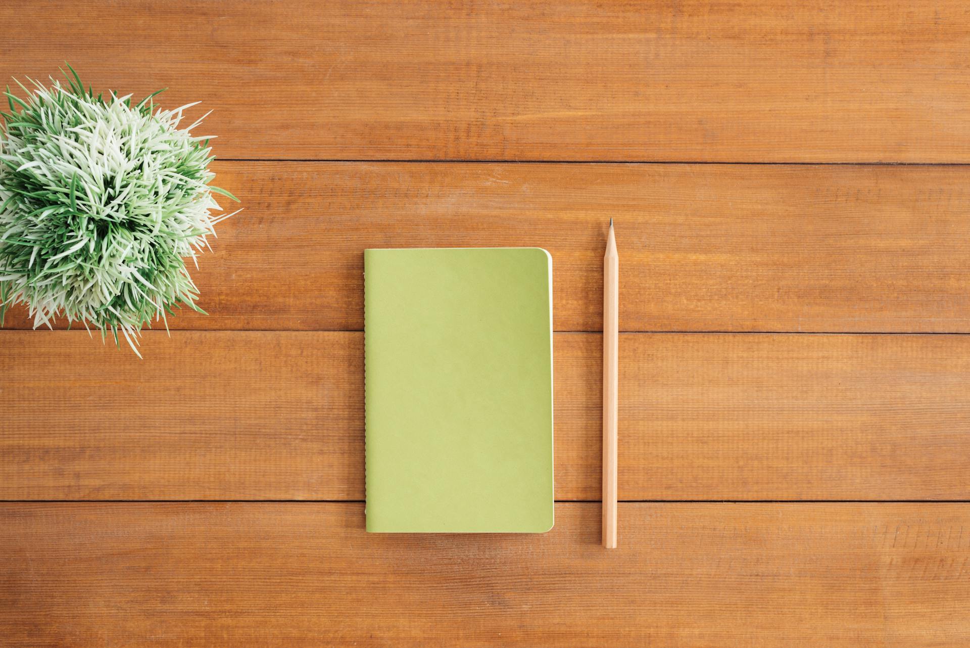 Un cuaderno y un lápiz sobre una mesa | Fuente: Pexels