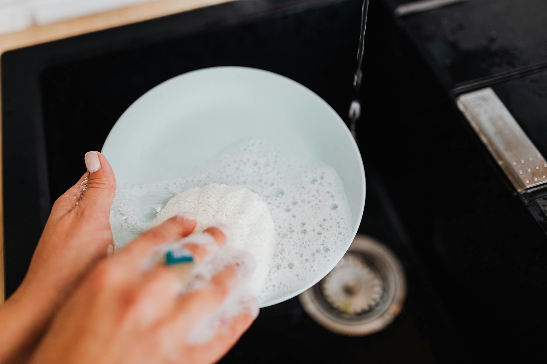 Una mujer lavando un plato | Fuente: Pexels