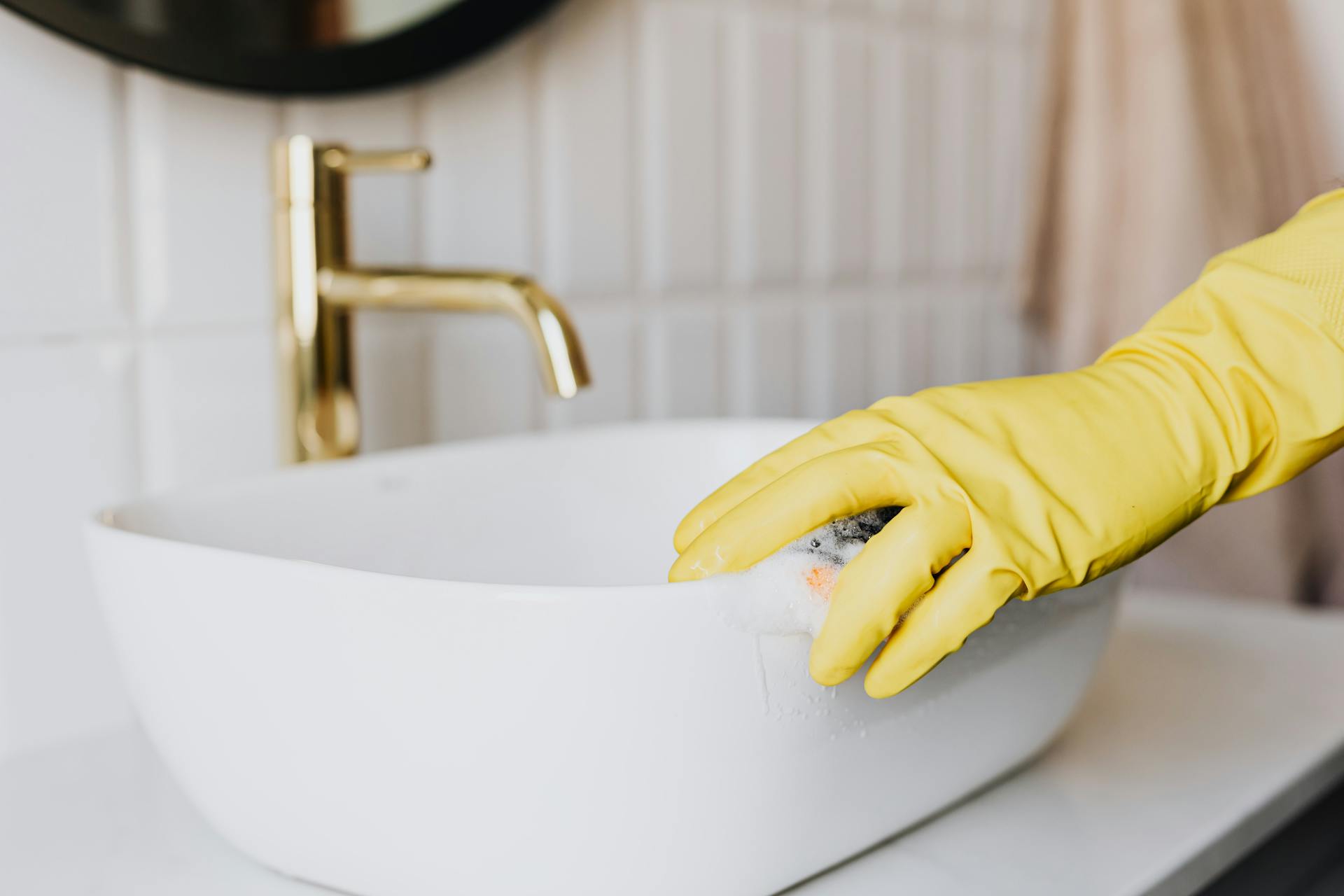 Una persona limpiando el lavabo de un baño | Fuente: Pexels