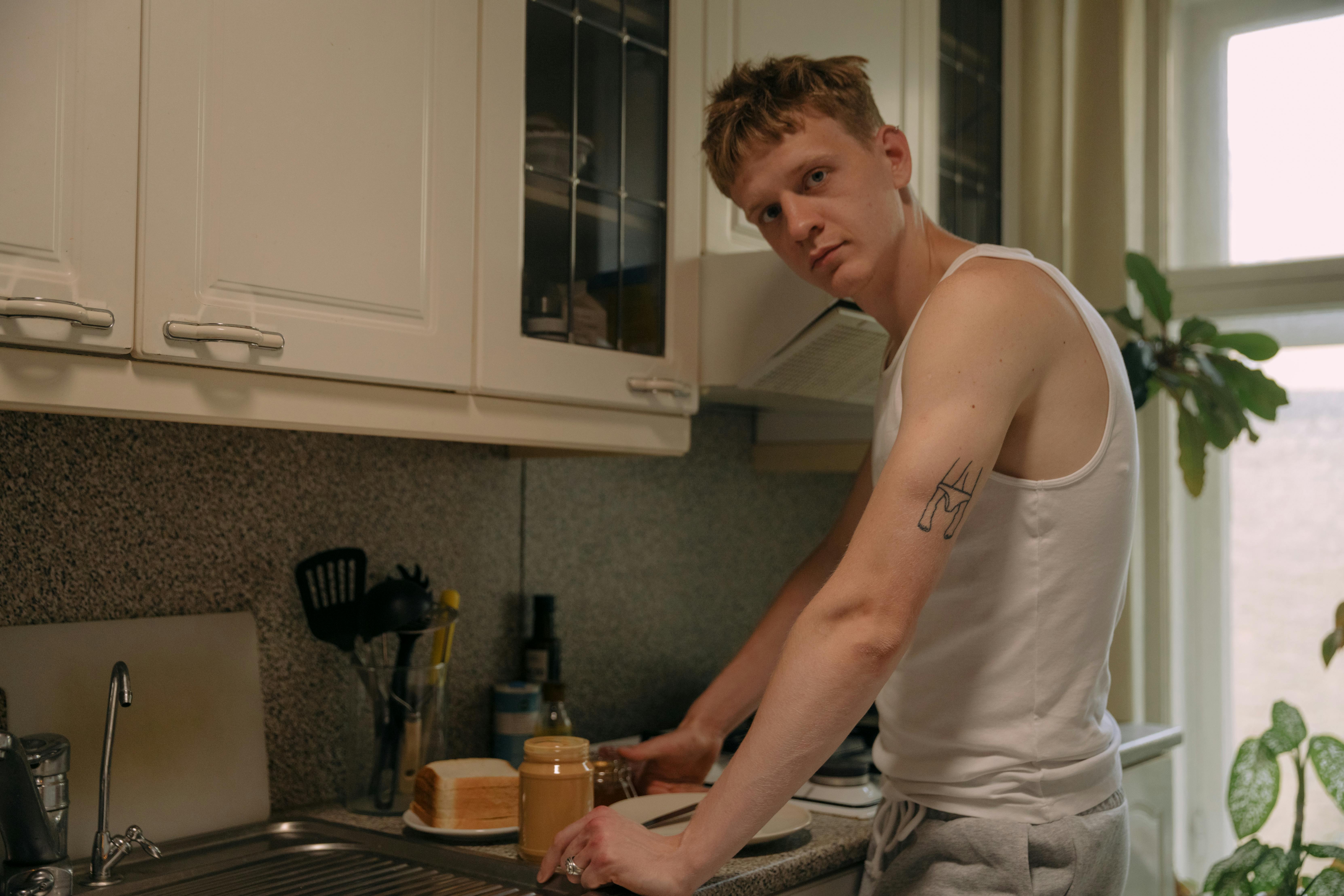 Un hombre de pie cerca de la encimera de la cocina | Fuente: Pexels