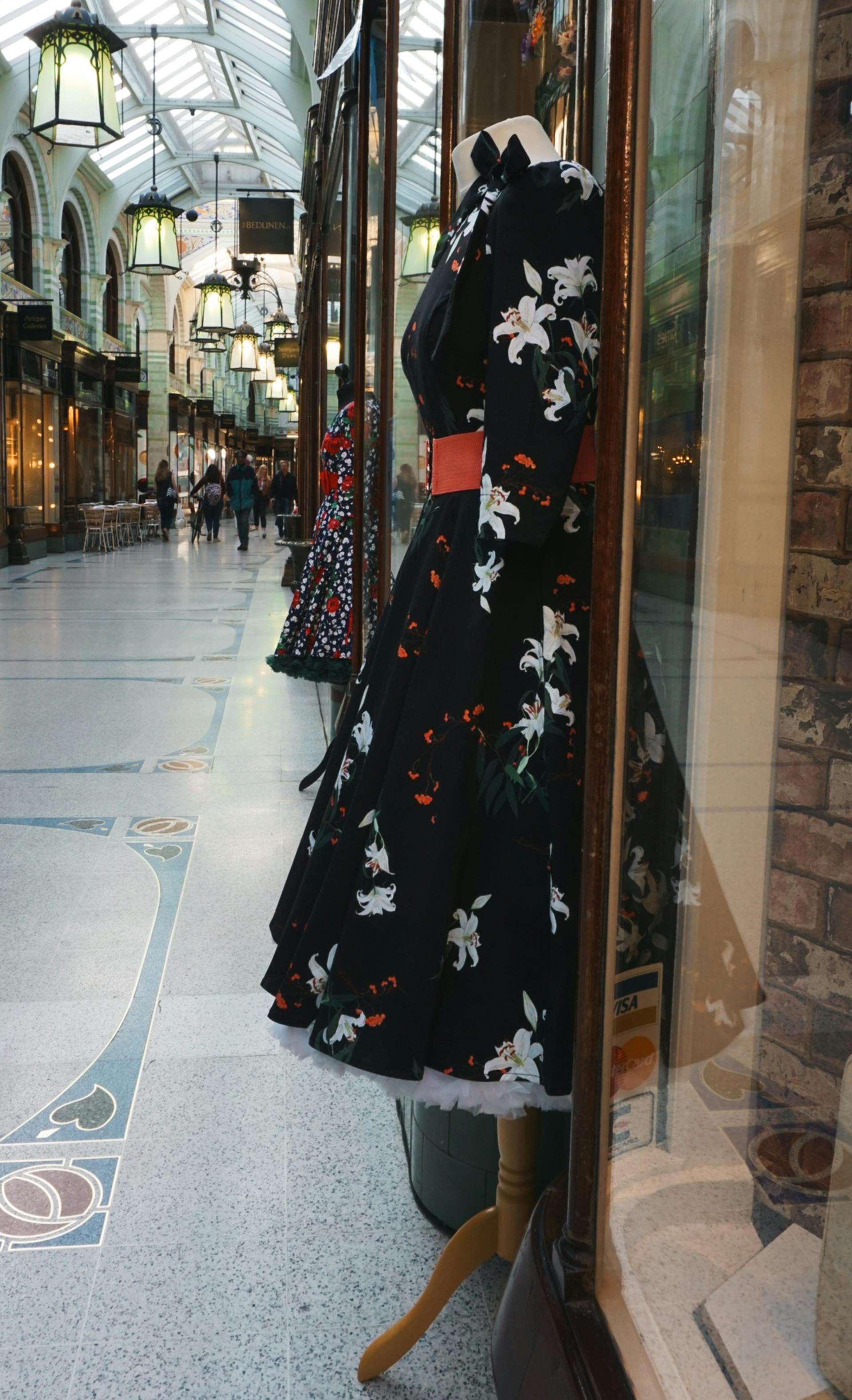 Vestidos expuestos fuera de una tienda en un centro comercial | Fuente: Pexels