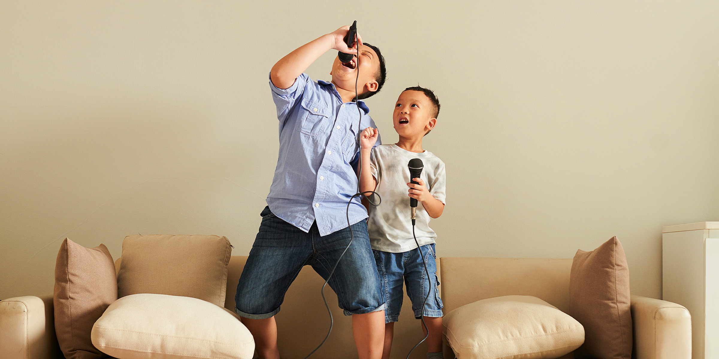 Dos chicos jugando con micrófonos | Fuente: Shutterstock