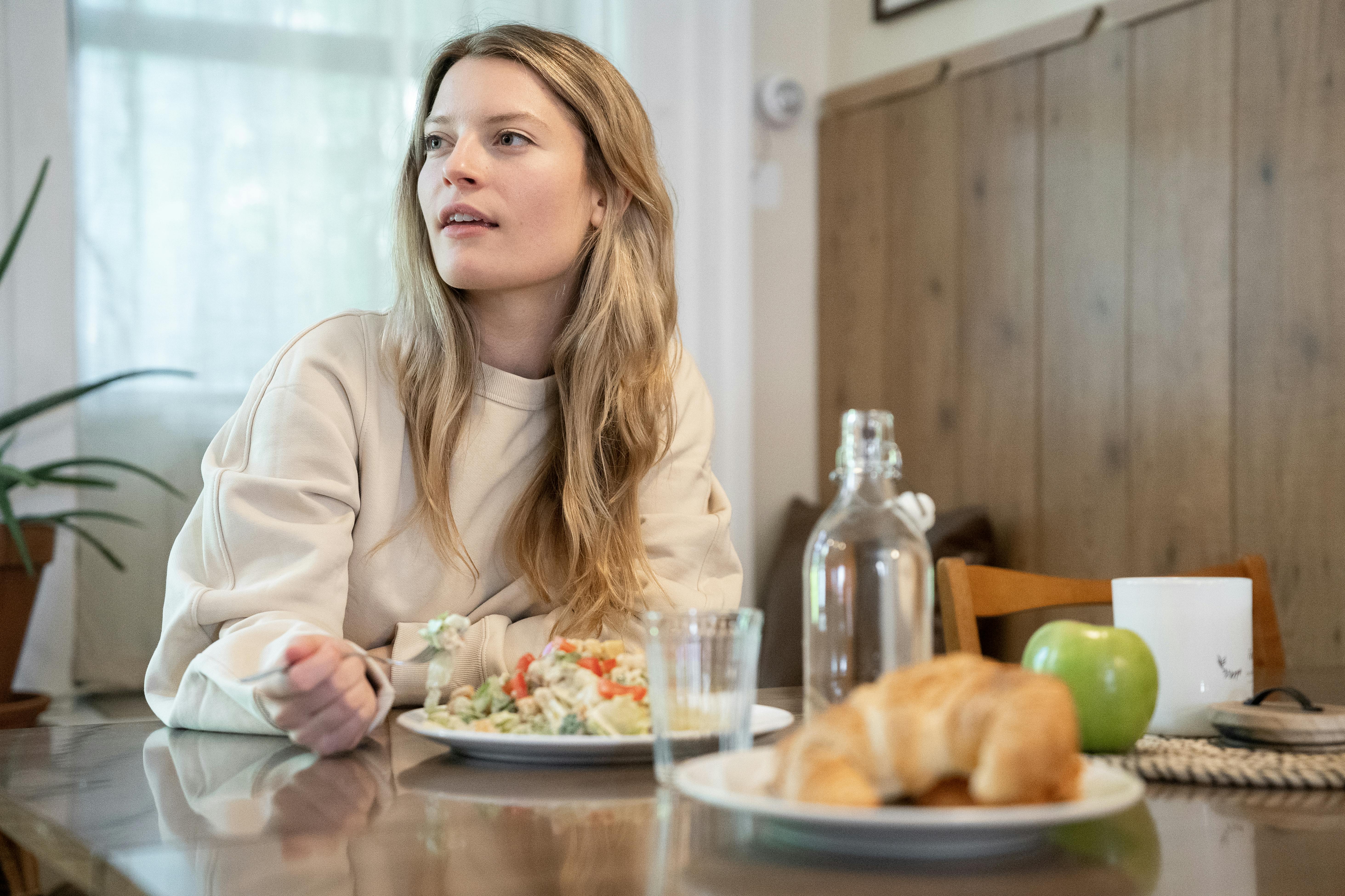 Una mujer confundida comiendo | Fuente: Pexels
