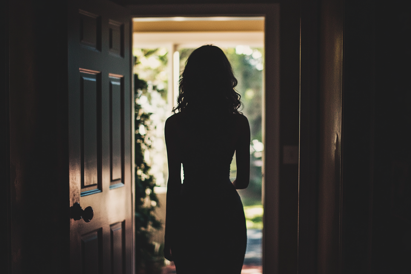 Una mujer silueteada en una puerta | Fuente: Midjourney