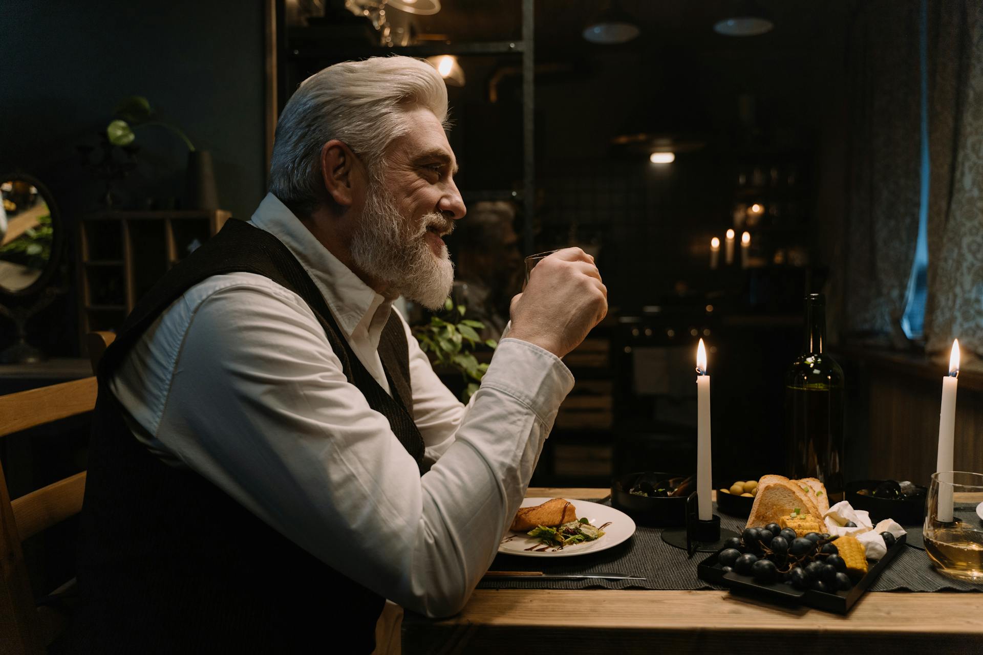 Un hombre mayor sentado en un comedor elegante y sonriente | Fuente: Pexels